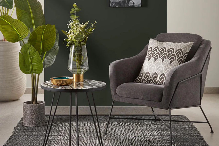 Brida Sessel von Kave Home in dunkelgrauem Samt mit schwarzem Stahlgestell, moderner Lounge-Stuhl mit abgerundeten Armlehnen und elegantem Design.