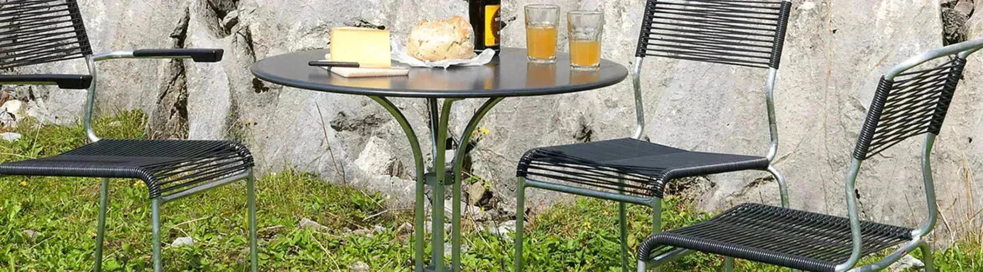 Entdecken Sie die St. Moritz Kollektion: elegante runde Gartentische und klassische Lättlistühle, Swiss Made, wetterfest und platzsparend.