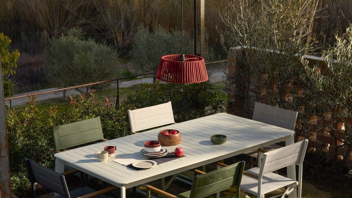 Ausziehtisch Brela von Kave Home aus Aluminium mit sechs passenden Gartenstühlen auf einer Terrasse