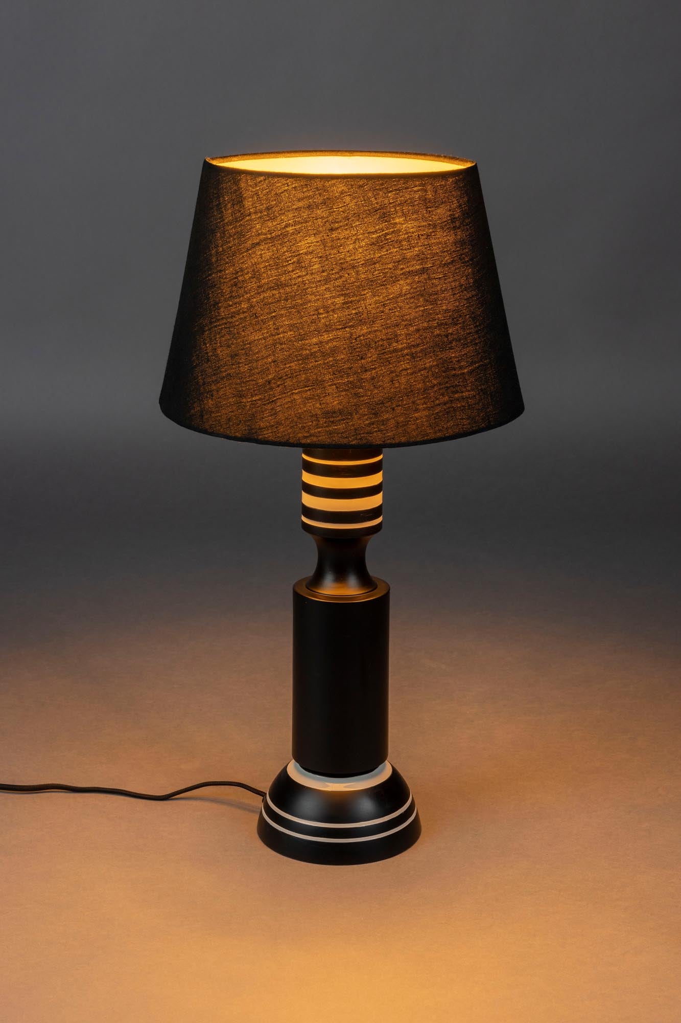 Die Tischlampe Virgil von Dutchbone kombiniert Retro-Design mit moderner Eleganz und sorgt für stilvolle Beleuchtung.