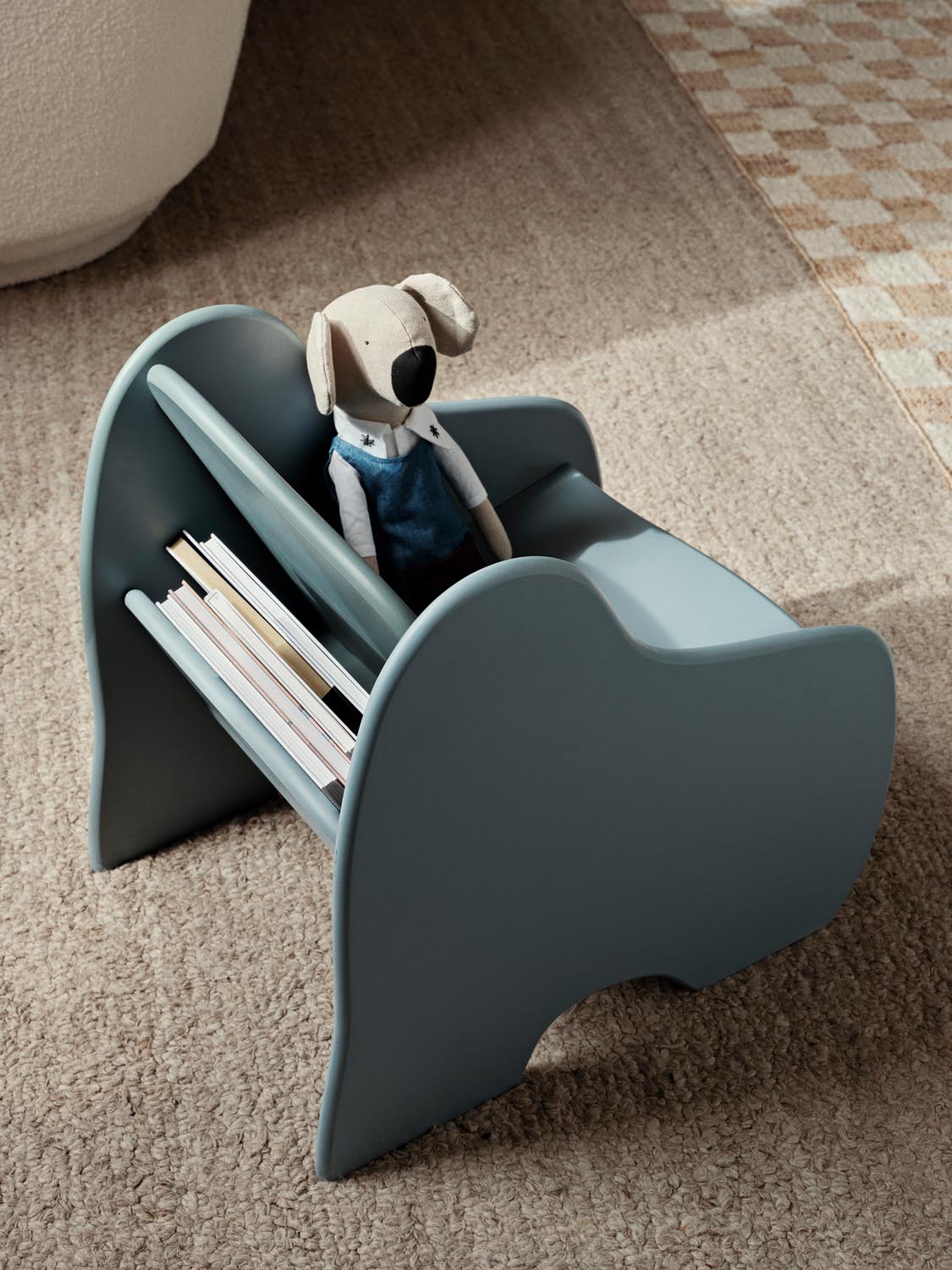 Der Slope Lounge Chair von Ferm Living: Ein verspielter Sessel mit integriertem Bücherregal, ideal für kreative Kinderzimmer.