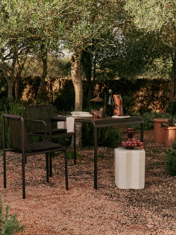 Erleben Sie den Dapple Esstisch 80 x 80 von Ferm Living – ein elegantes, wetterfestes Möbelstück für entspannte Momente im Freien.