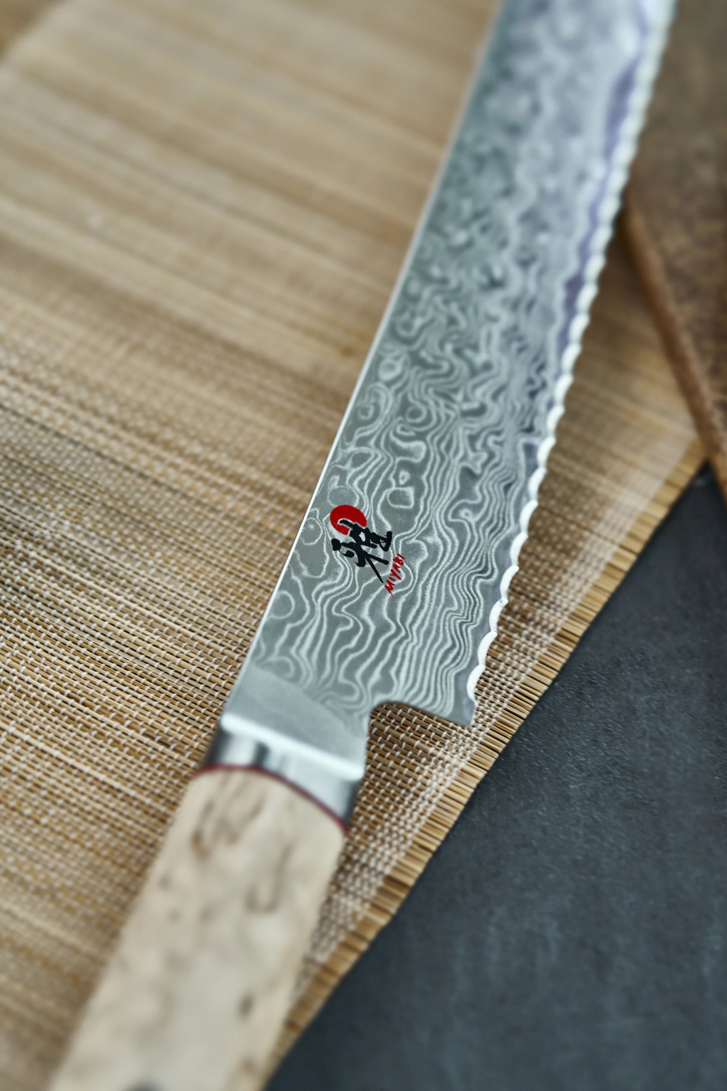 Elegantes MIYABI 5000MCD Brotmesser mit 230mm Klinge aus hochwertigem Damaststahl, perfekt für sauberes und müheloses Schneiden von Brot.