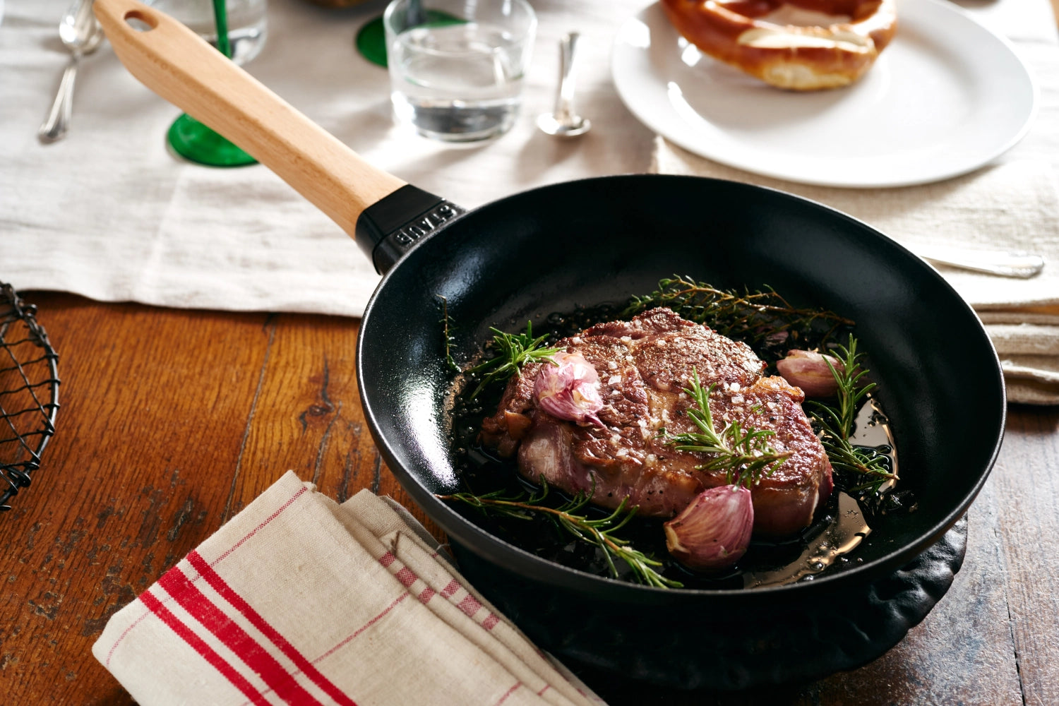 Elegante Staub Bratpfanne mit ergonomischem Holzgriff, 32 cm Durchmesser, perfekt für köstliche Bratgerichte und gleichmäßige Wärmeverteilung.