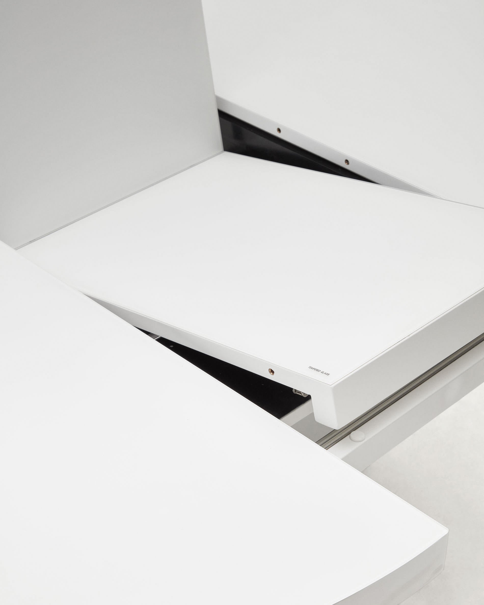 Entdecken Sie den eleganten Vashti Ausziehtisch von Kave Home, Ø120(160)x120cm, mit widerstandsfähiger Glasplatte und stabilen weißen Stahlbeinen – ideal für gesellige Runden.