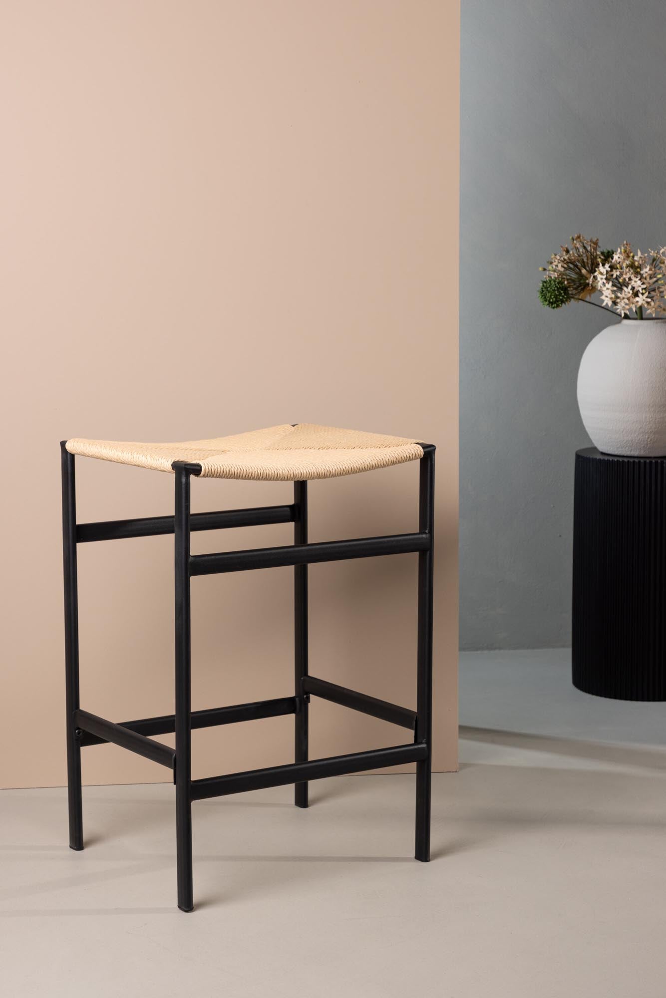 Der Polly Barstuhl von Venture Home kombiniert eleganten Seilsitz mit robusten Stahlbeinen und bietet hohen Komfort sowie vielseitige Einsatzmöglichkeiten.