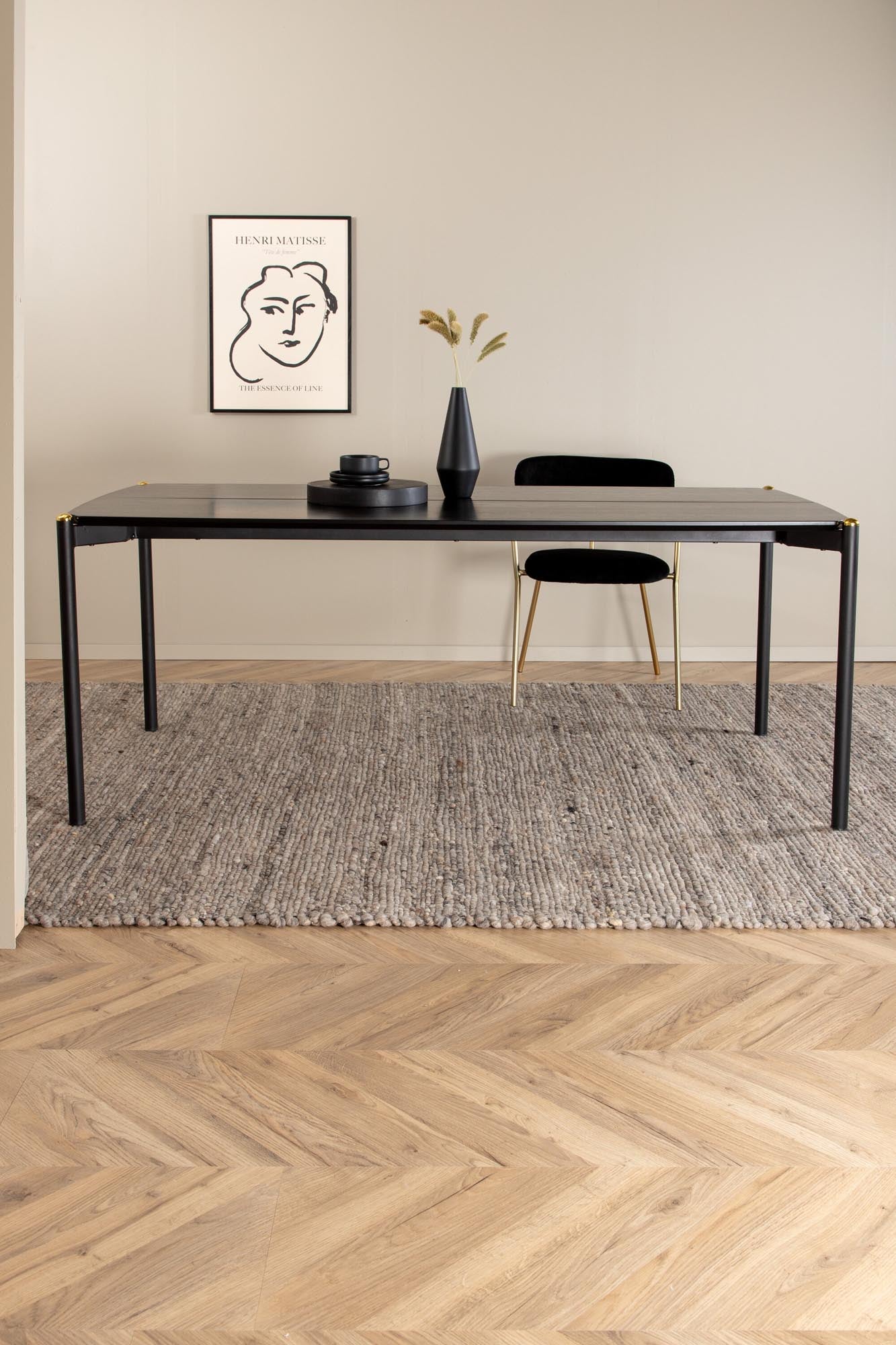 Entdecken Sie den Pelle Esstisch von Venture Home: stilvolles, elegantes Design, robuste MDF-Oberfläche, filigrane Eisenbeine und edle Messingakzente.