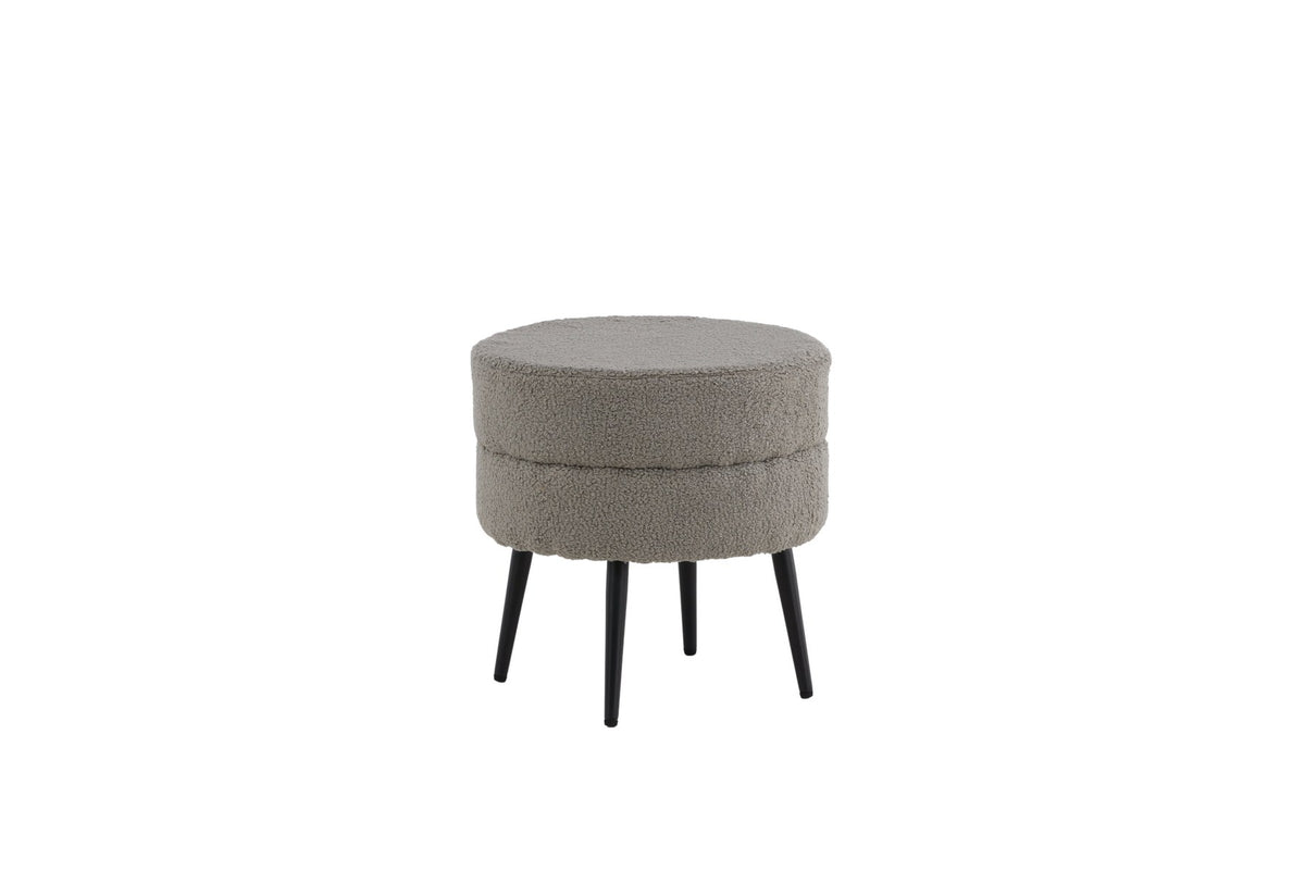 Runder Pouf Pot in Grau mit Teddystoff-Bezug, Durchmesser 40 cm, auf schwarzen, leicht ausgestellten Stahlbeinen stehend.