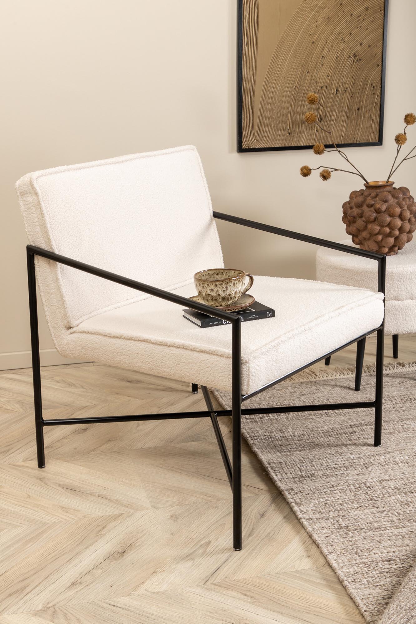 Entdecken Sie den Rakel Sessel von Venture Home: Ein stilvolles Möbelstück mit kuscheligem Teddy-Stoff und modernem Metallgestell für höchsten Komfort.