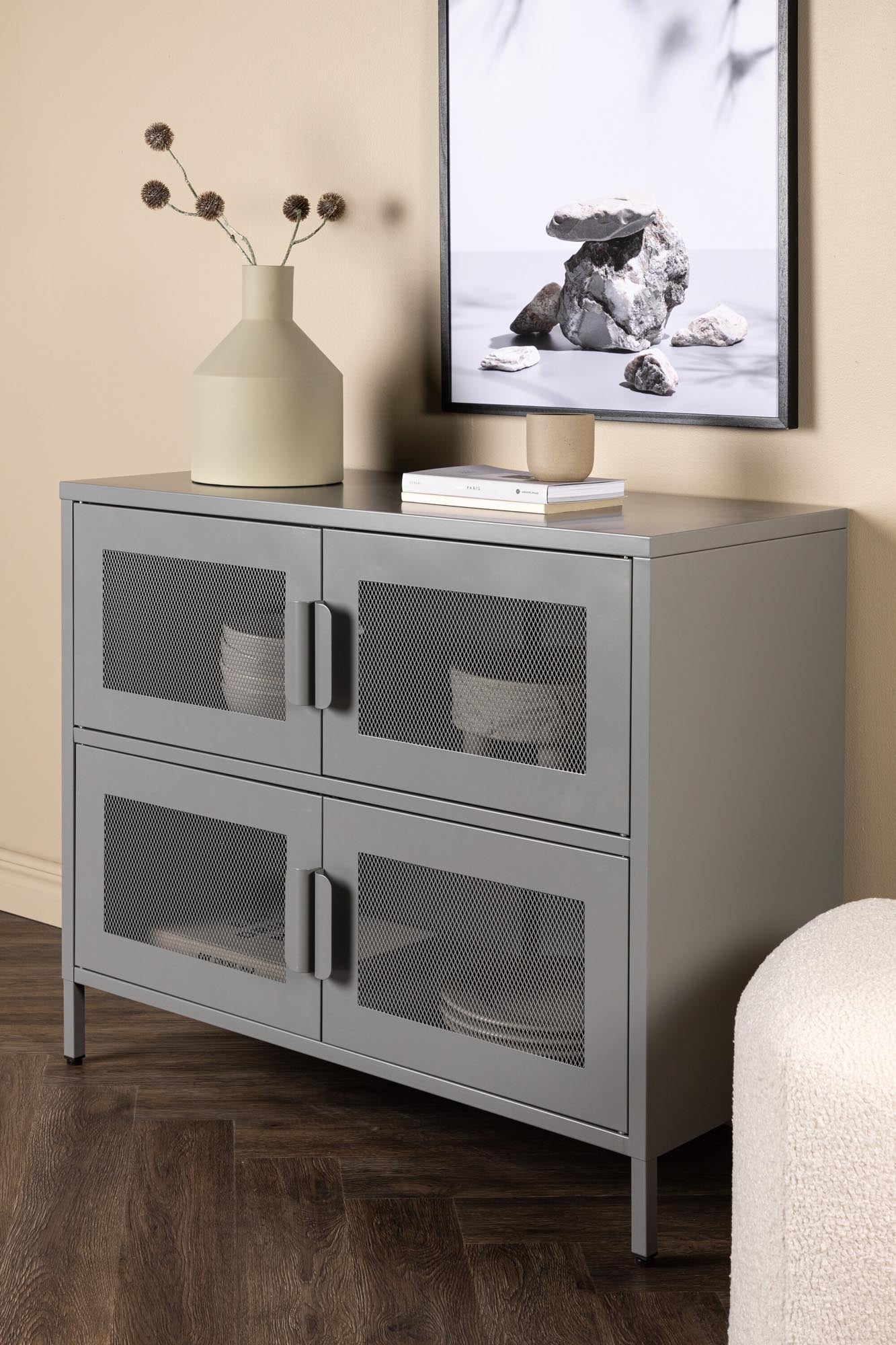 Entdecken Sie das Nett Kabinett von Venture Home: Ein eleganter Aufbewahrungsschrank aus beigem Stahl mit funktionalen Netzluken und stilvollen, schmalen Beinen.