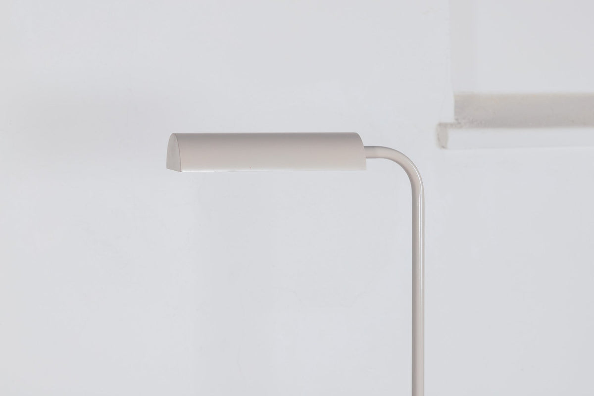 Schlanke Stehleuchte in Beige aus PVC und Stahl, schmaler Lampenschirm auf hohem Standfuss, schlichte moderne Form.