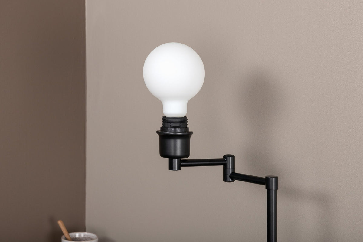 Schwarze Virro Tischleuchte aus PVC und Stahl mit verstellbarem Ständer und offen sichtbarer Glühbirne, freistehend fotografiert.