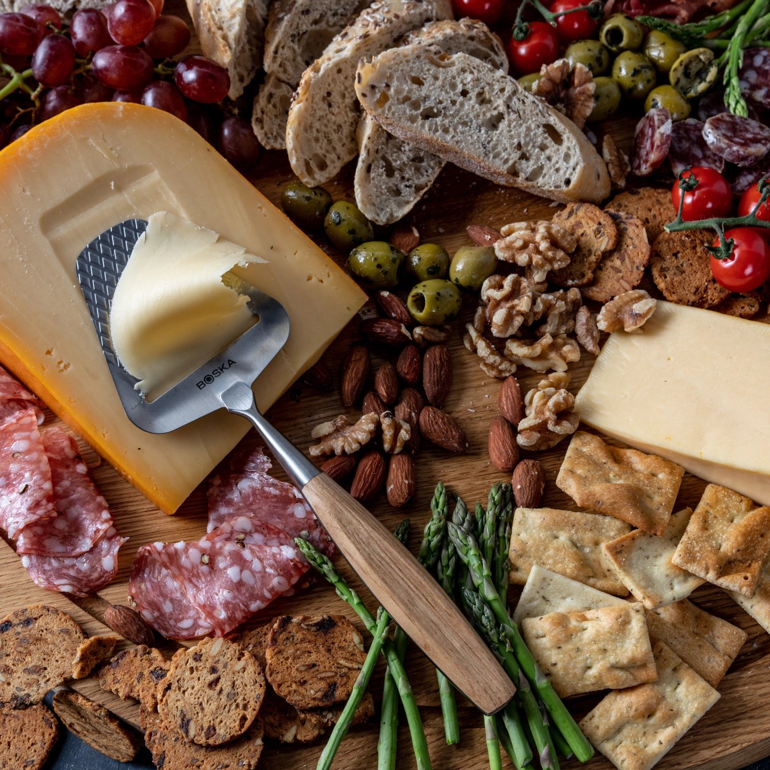 Der Käsehobel Oslo+ von Boska vereint elegantes Design und Funktionalität. Aus robustem Edelstahl und mit einem stilvollen Eichenholzgriff, ideal für Käseliebhaber.