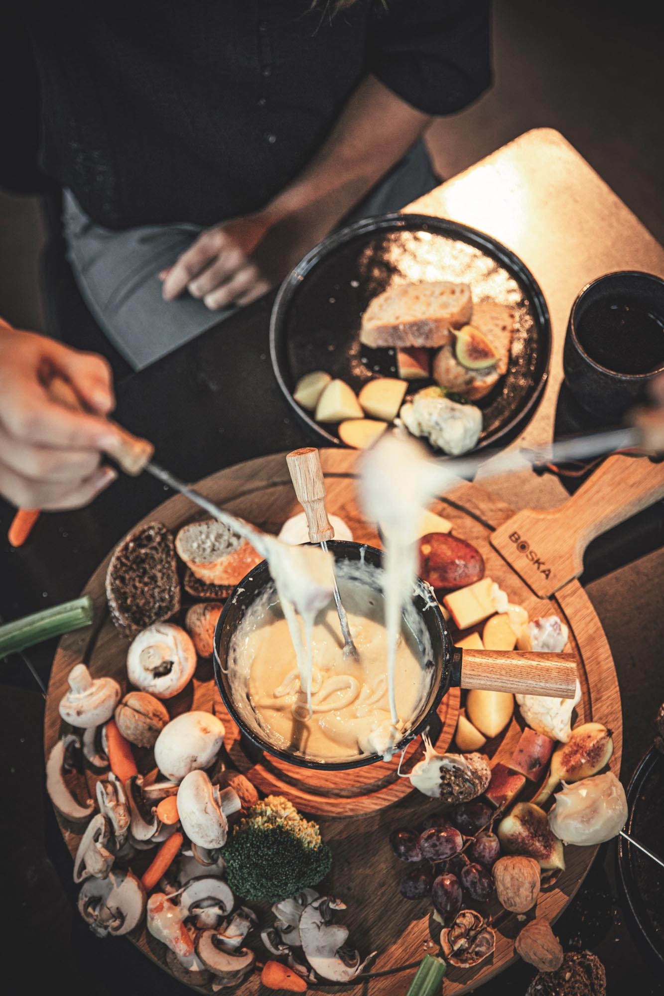 Fondueset Pro S von Boska: Hochwertiges Gusseisen und elegantes Eichenholz für perfekte Fondue-Momente mit Freunden und Familie.