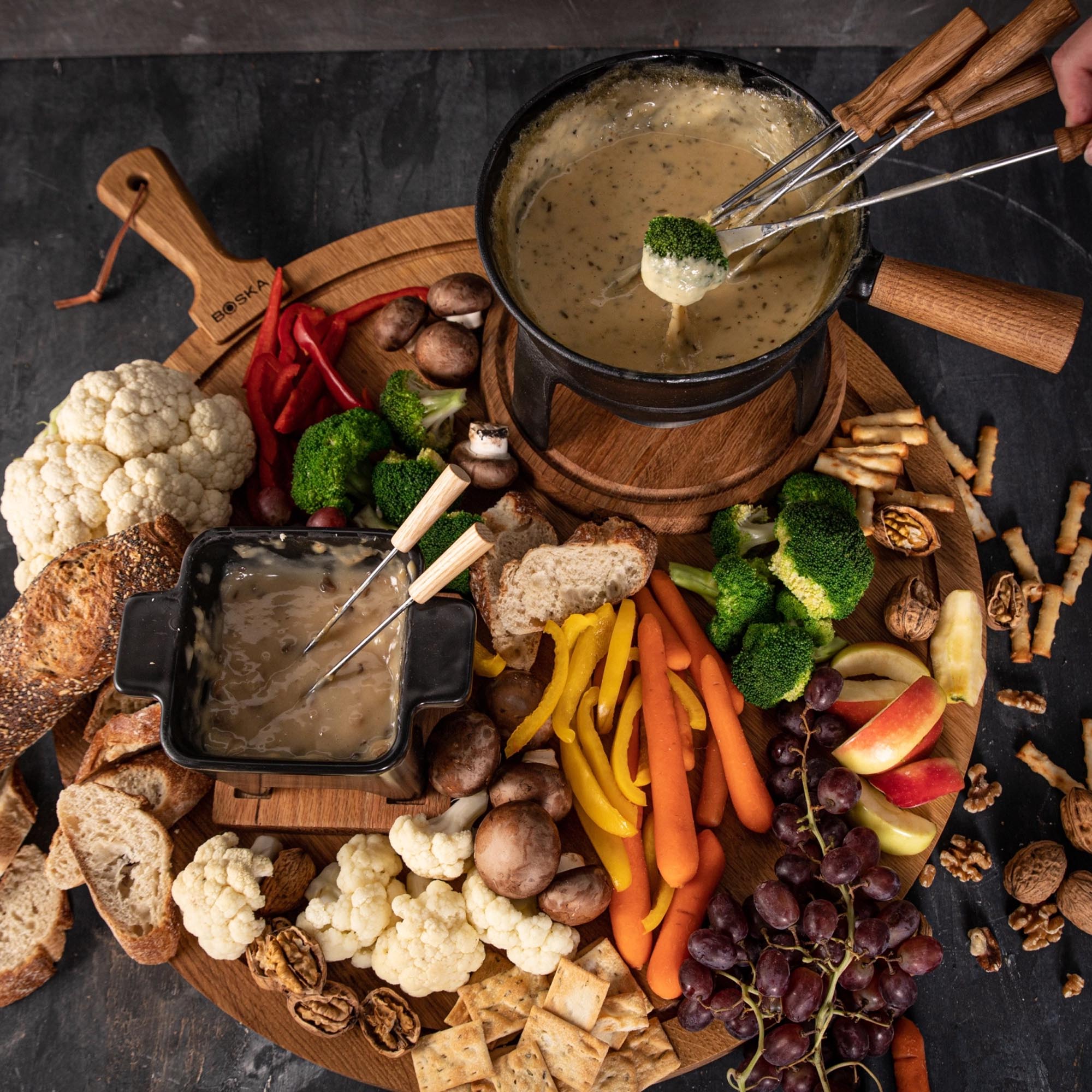 Erleben Sie gesellige Abende mit dem Fondueset Pro L von Boska. 1,8L Gusseisen für gleichmäßige Wärme, stabiler Eichenholzständer, ideal für Fondue.