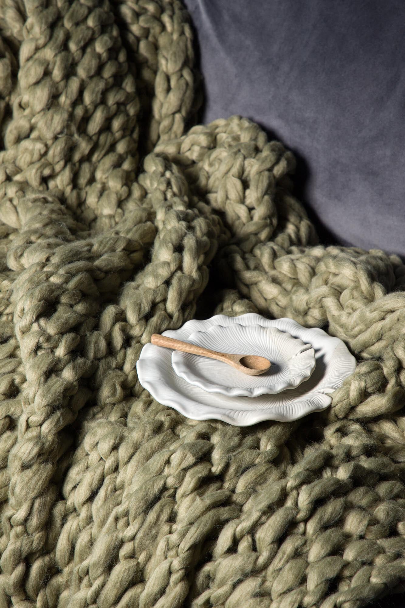 Kuschelige Kate Throw in sanftem Beige, ideal für gemütliche Stunden auf dem Sofa.