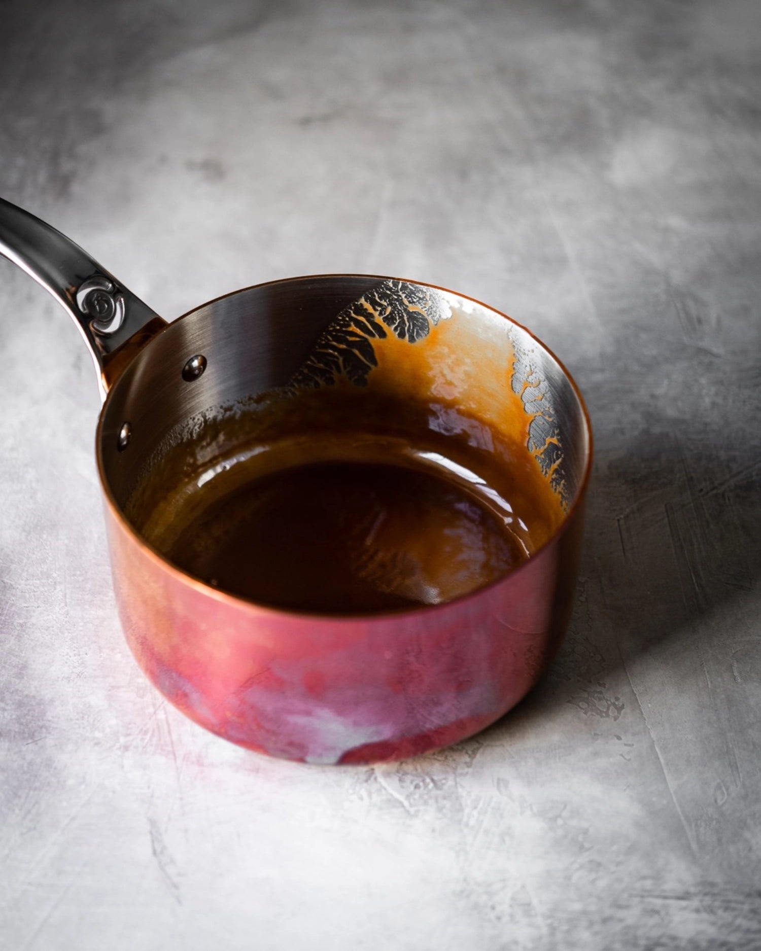 Entdecken Sie die PRIMA MATERA Stielkasserolle (Ø14cm) von de Buyer – eine perfekte Kombination aus Kupfer und Edelstahl für gleichmäßiges Kochen auf Induktionsherden.