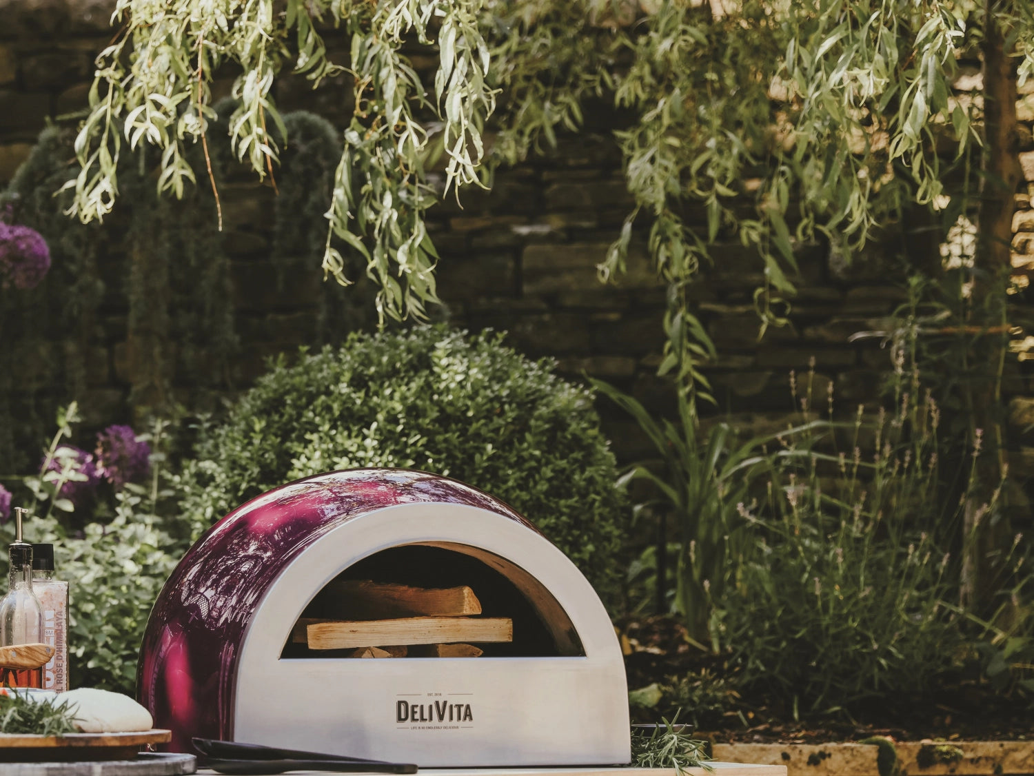 Stylischer Pizzaofen in Beerenrot von Delivita, ideal für die Zubereitung köstlicher Pizzen im Freien, vereint Funktionalität und Ästhetik.