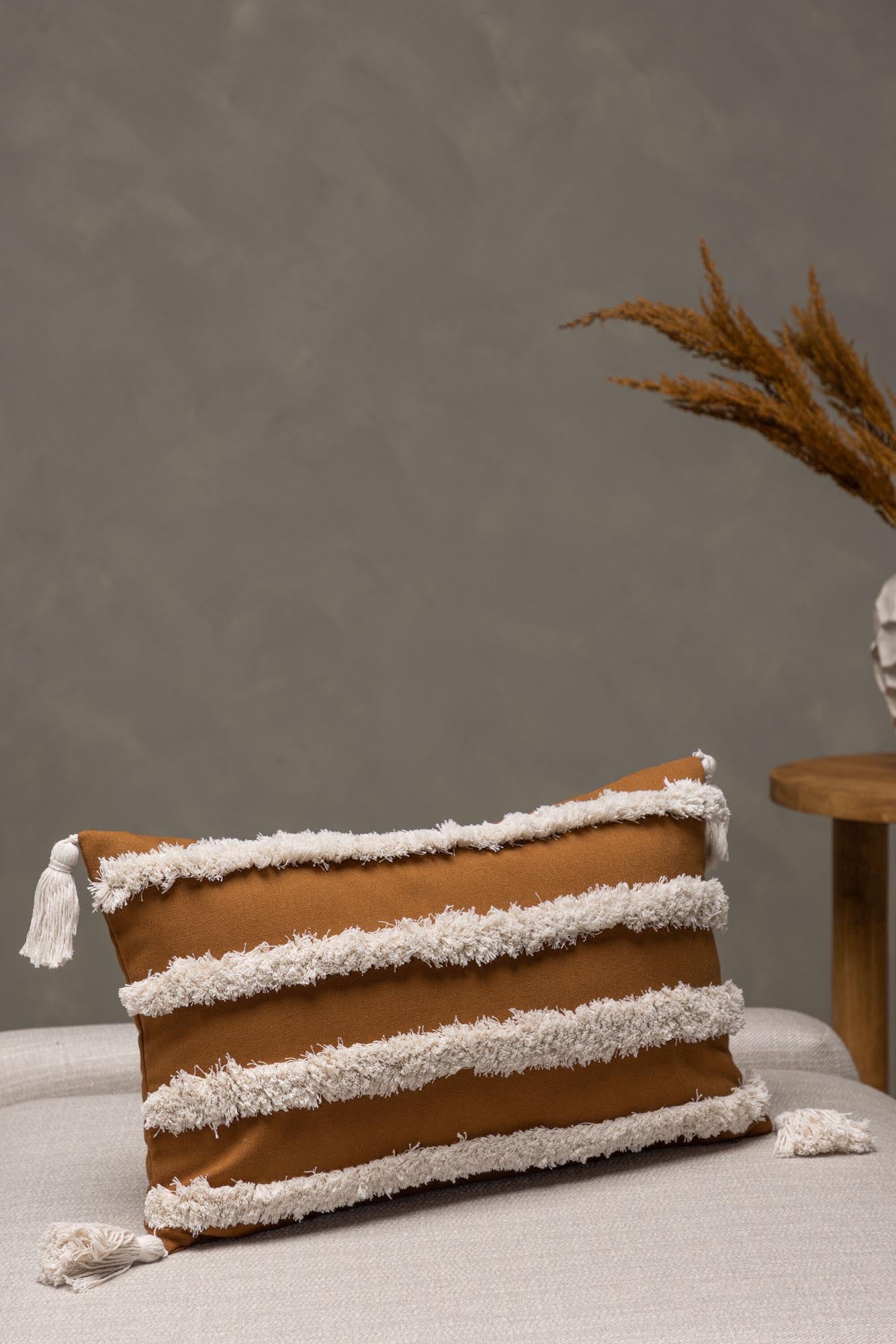 Eleganter Elina Kissenbezug in warmem Rostton mit stilvollen Quasten.