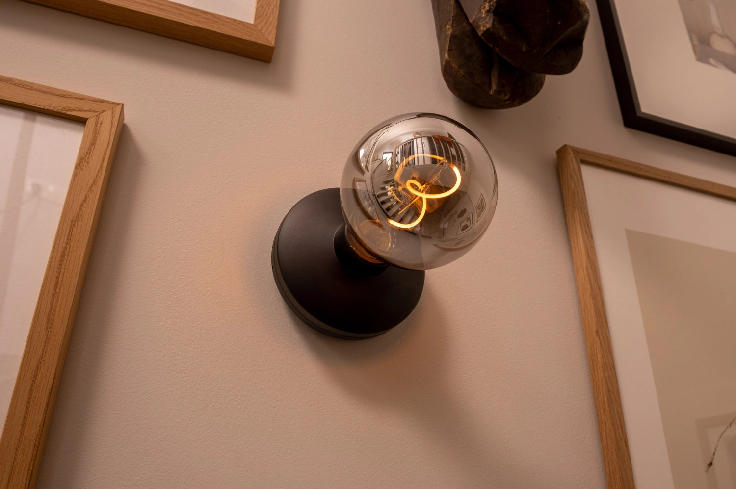 Die Humble Bee Wandlampe in Schwarz-Rauch sorgt für eine warme Atmosphäre und stilvolle Akzente in Ihrem Zuhause. Ideal für modernes Wohndesign.