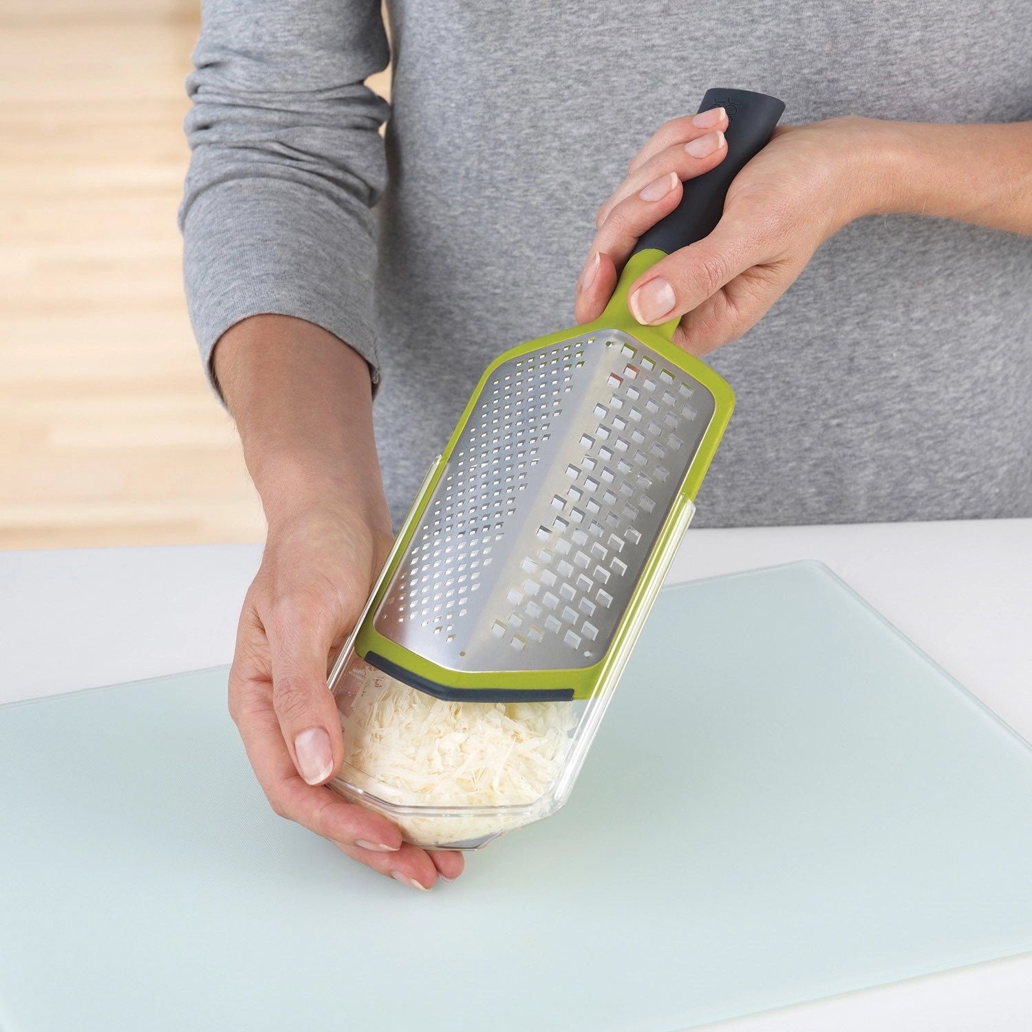 Praktische grüne Twist Reibe mit Auffangbehälter, perfekt für das mühelose Reiben von Käse und Gemüse in grob oder fein.
