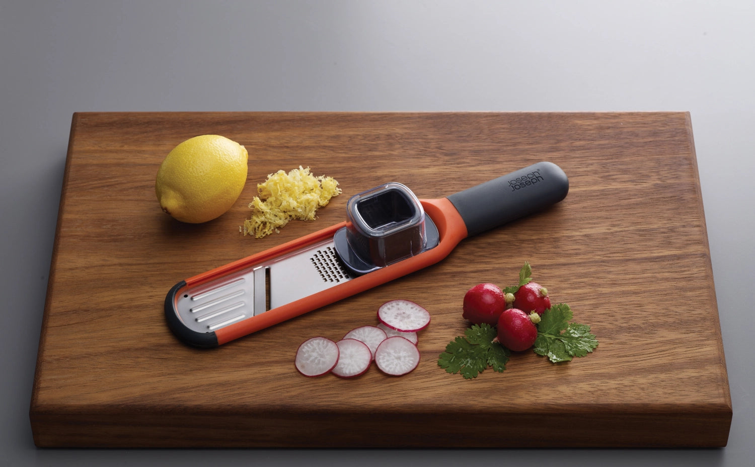 Handi-Grate 2-in-1 Mini Reibe in leuchtendem Orange, kompakt und vielseitig, perfekt für die Küche, Maße: 28.5x5.7x4.3 cm.