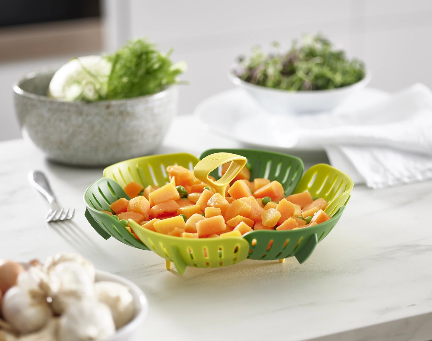 Faltbarer Dampfgareinsatz in frischem Grün von Joseph Joseph, ideal für gesundes Kochen und einfache Lagerung in der Küche.