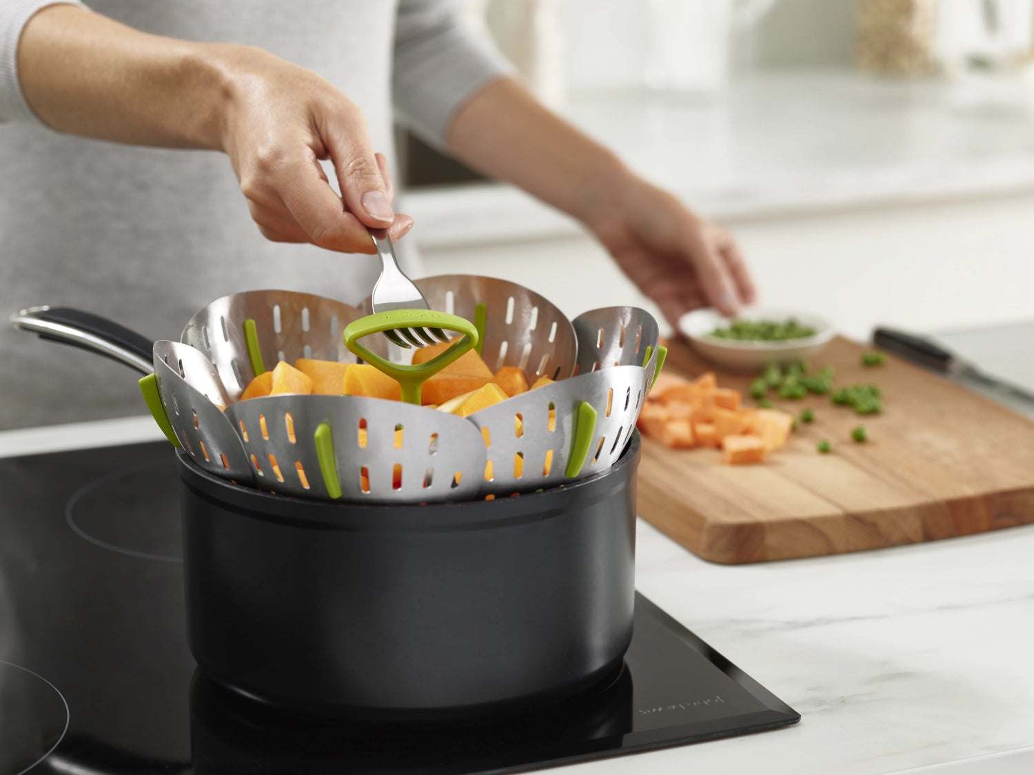 Stylischer und funktionaler Dampfgarein aus Edelstahl in frischem Grün, perfekt für gesundes Kochen und platzsparend zusammenklappbar.