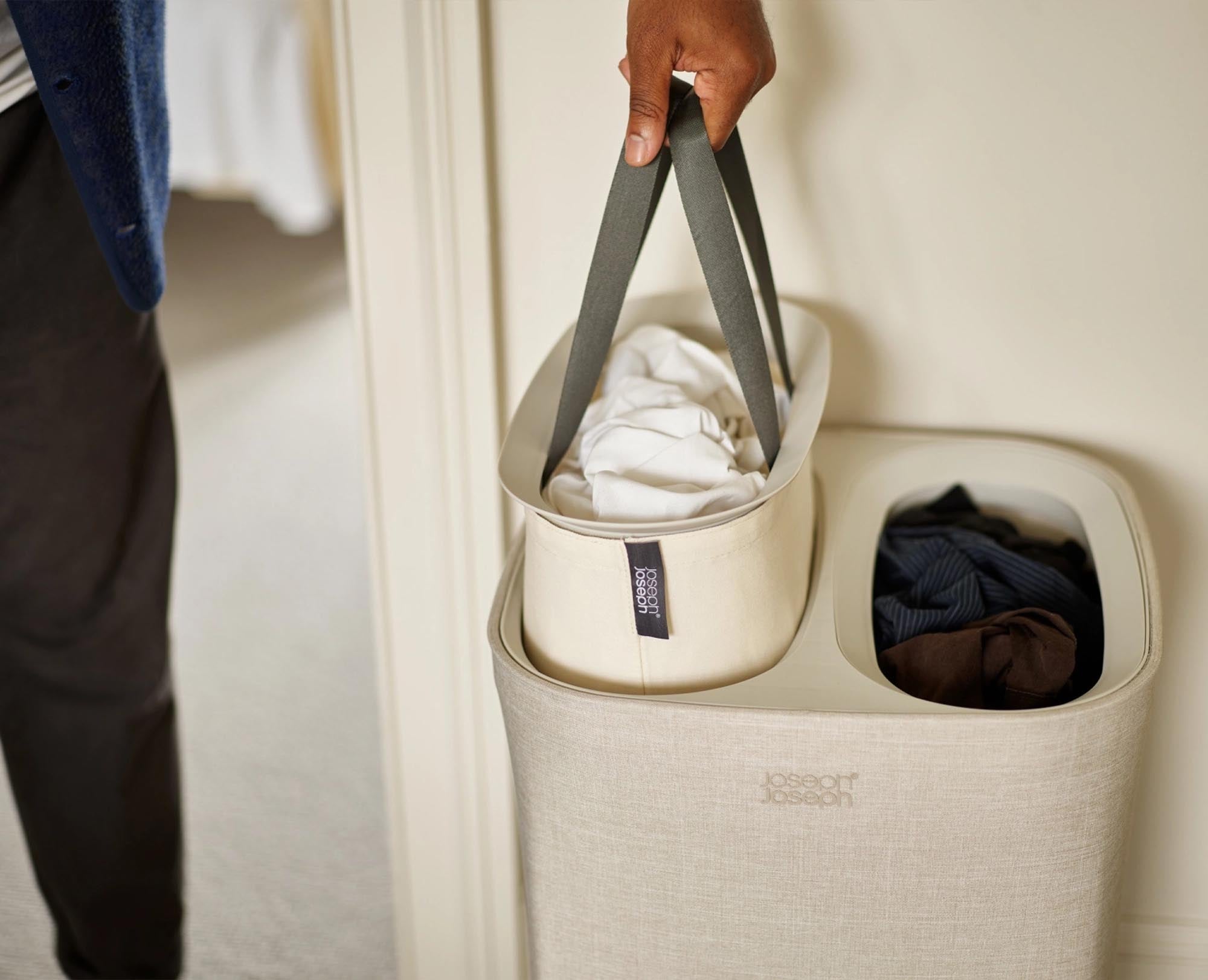 Stylischer 60L Wäschekorb in Ecru von Joseph Joseph: robustes Design, optimale Luftzirkulation und ergonomische Griffe für müheloses Tragen.