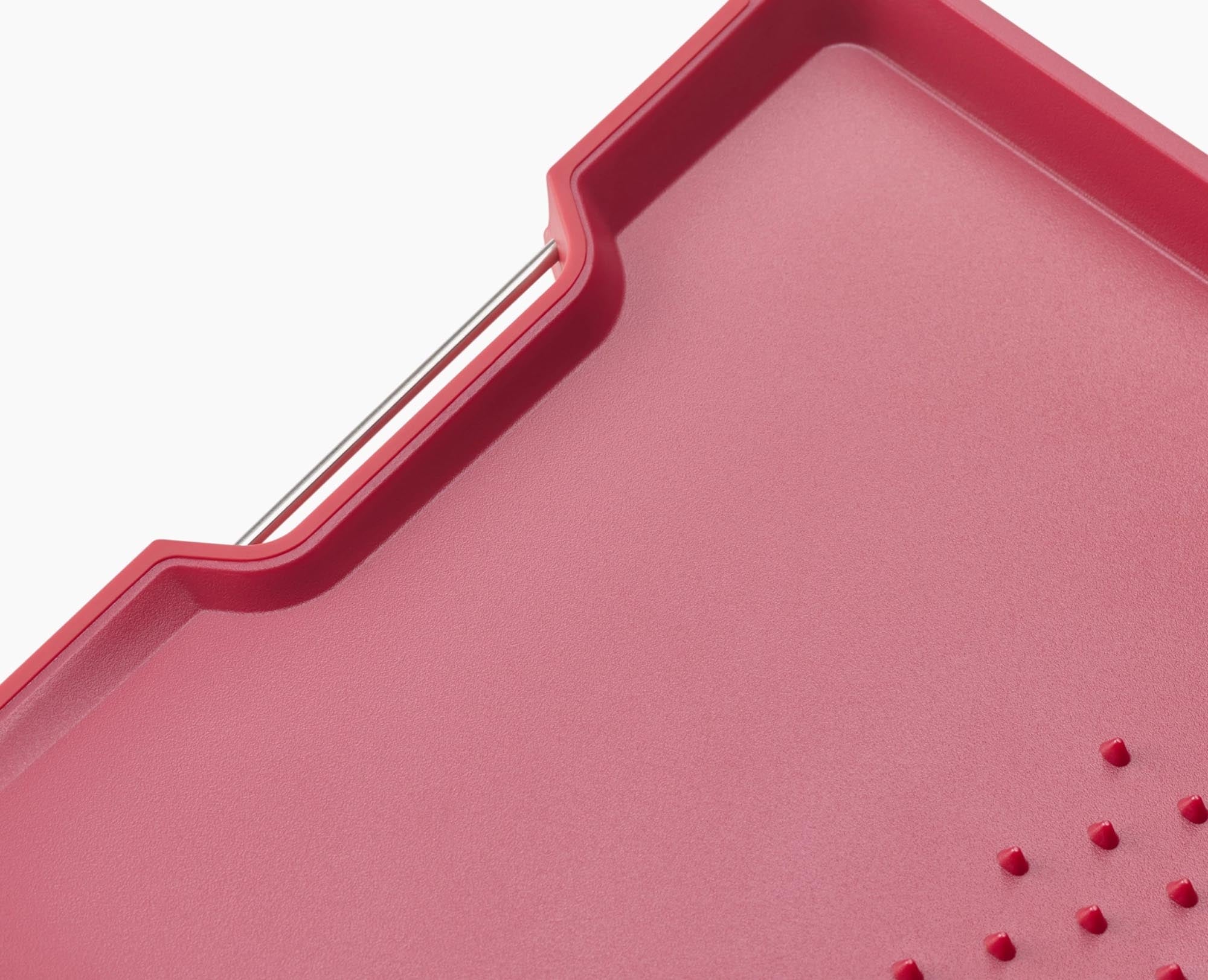 Grosses, rotes Schneidebrett mit innovativer Saftrille von Joseph Joseph.