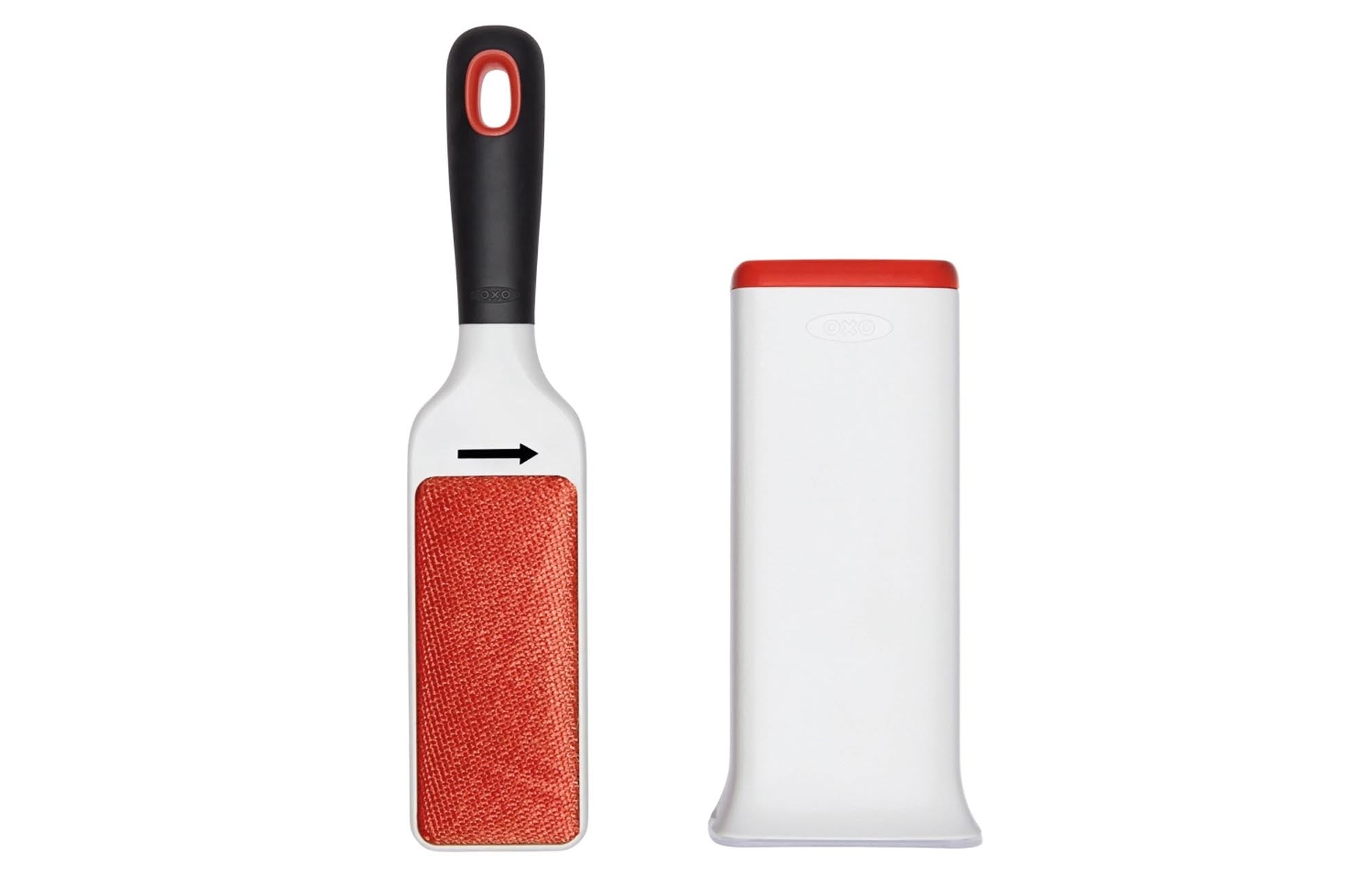 Die OXO Flusenentferner-Bürste in Weiss-Orange entfernt effektiv Flusen und Tierhaare von Kleidung, ohne die Fasern zu beschädigen.