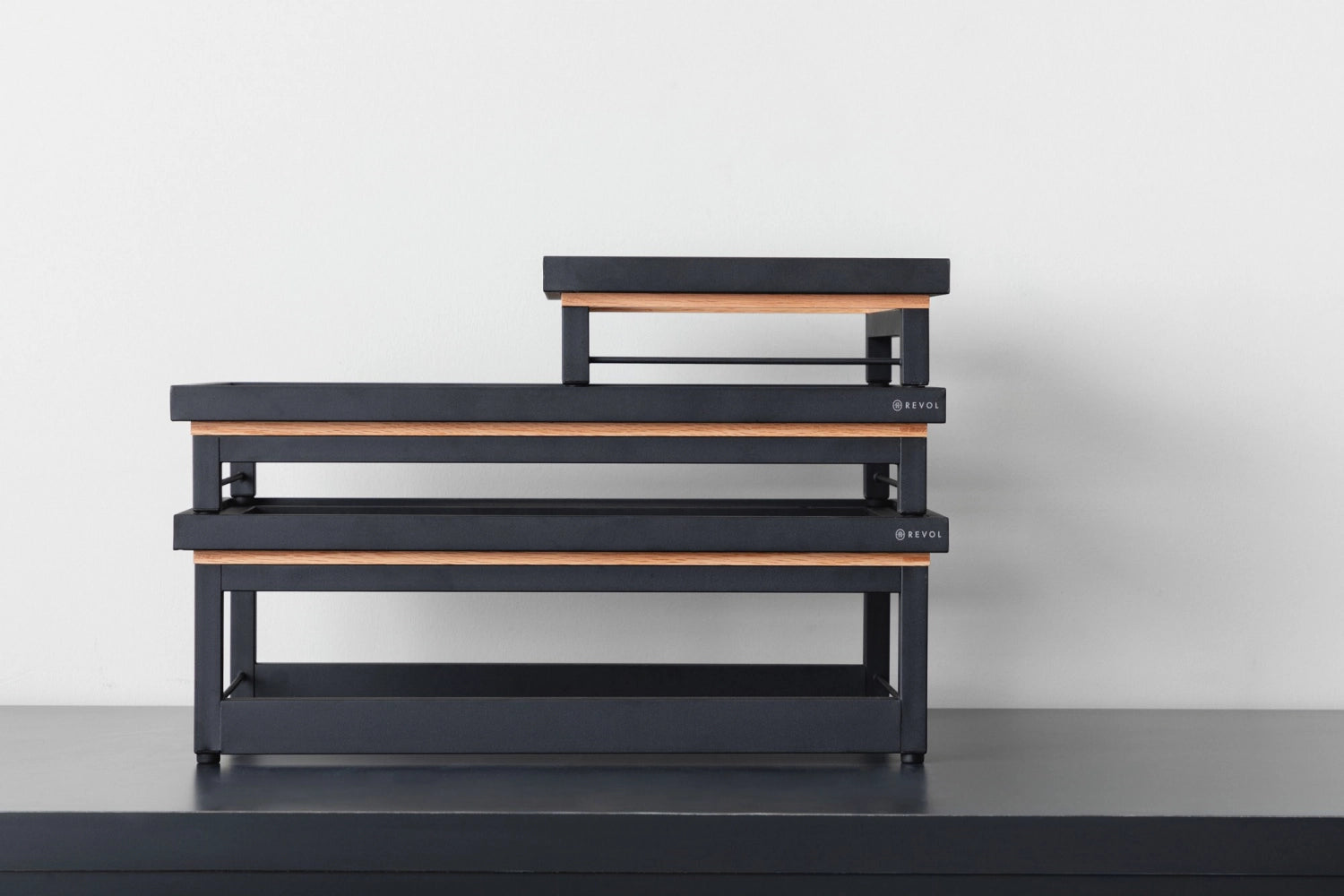 Stilvoller En Scene Presenter GN 1/1 aus mattem Schwarzmetall und Eichenrah von Revol. Perfekt für ansprechende Buffets und elegante Servierlösungen.