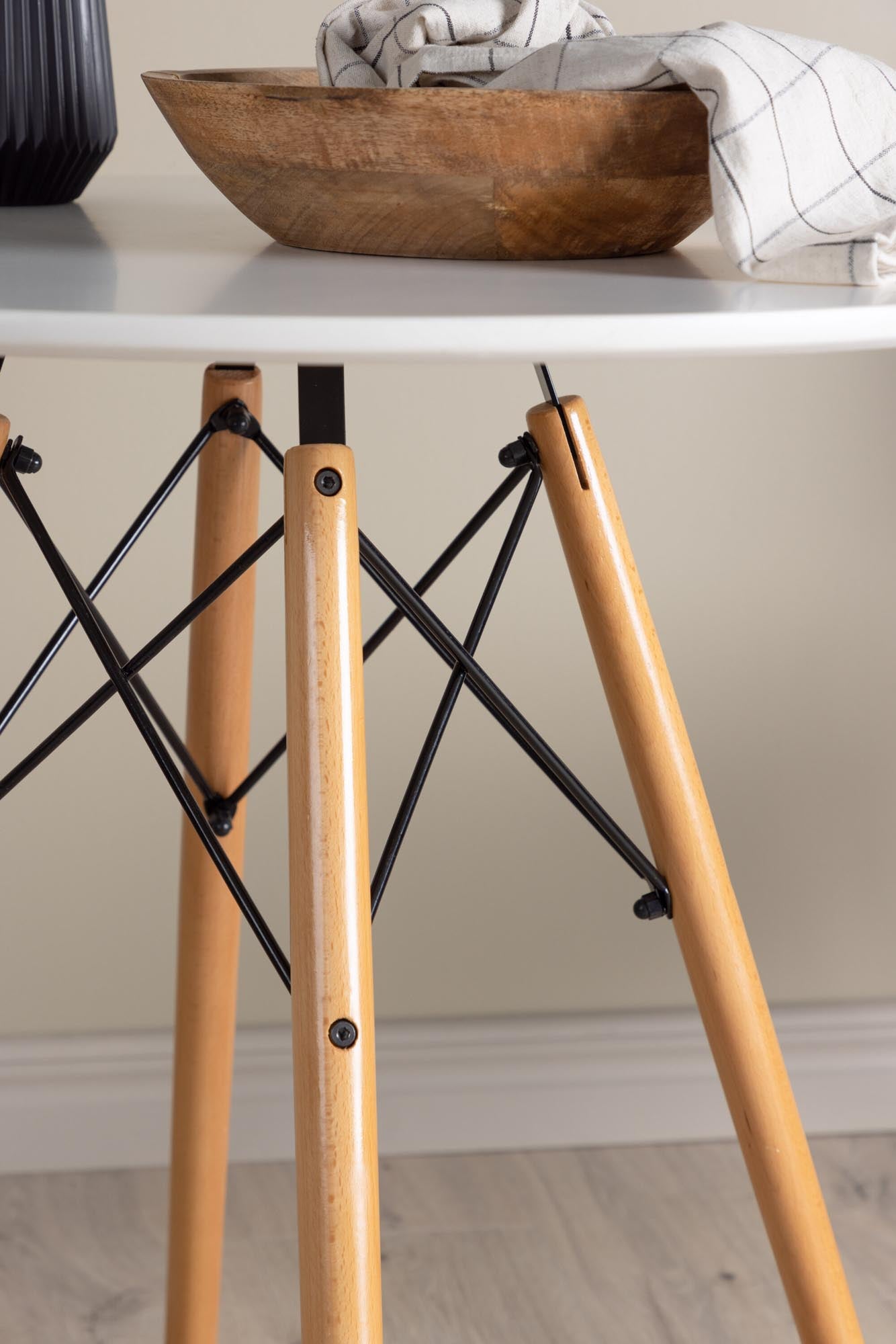 Eleganter runder Esstisch mit weisser MDF-Platte, Buchenholzbeinen und schwarzen Stahldetails für stilvolle Mahlzeiten.