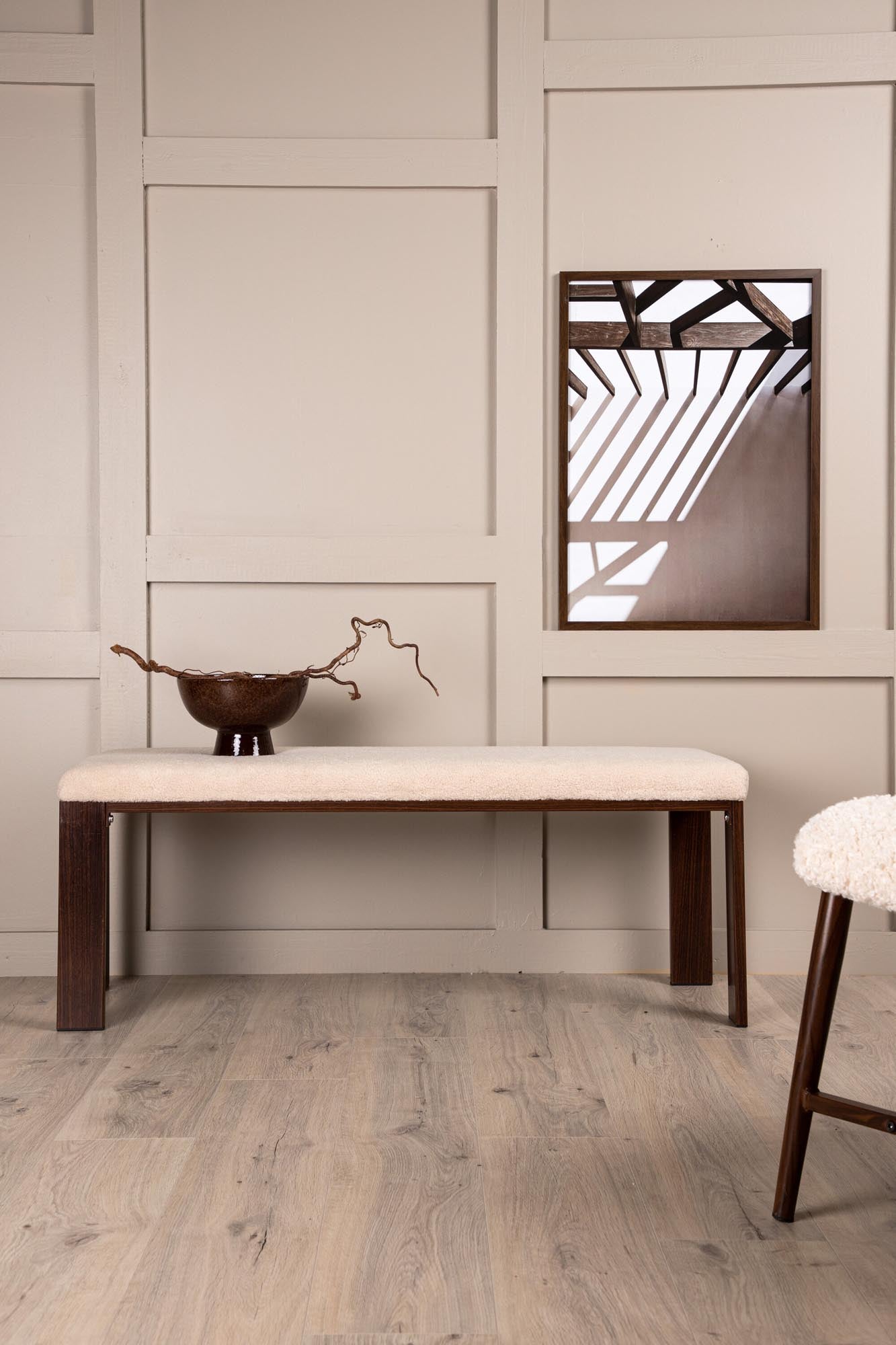 Elegante Chester Bank: Weisser Fleecestoff, Walnussholzbeine, Stahlkonstruktion. Komfort & Luxus für jeden Raum.