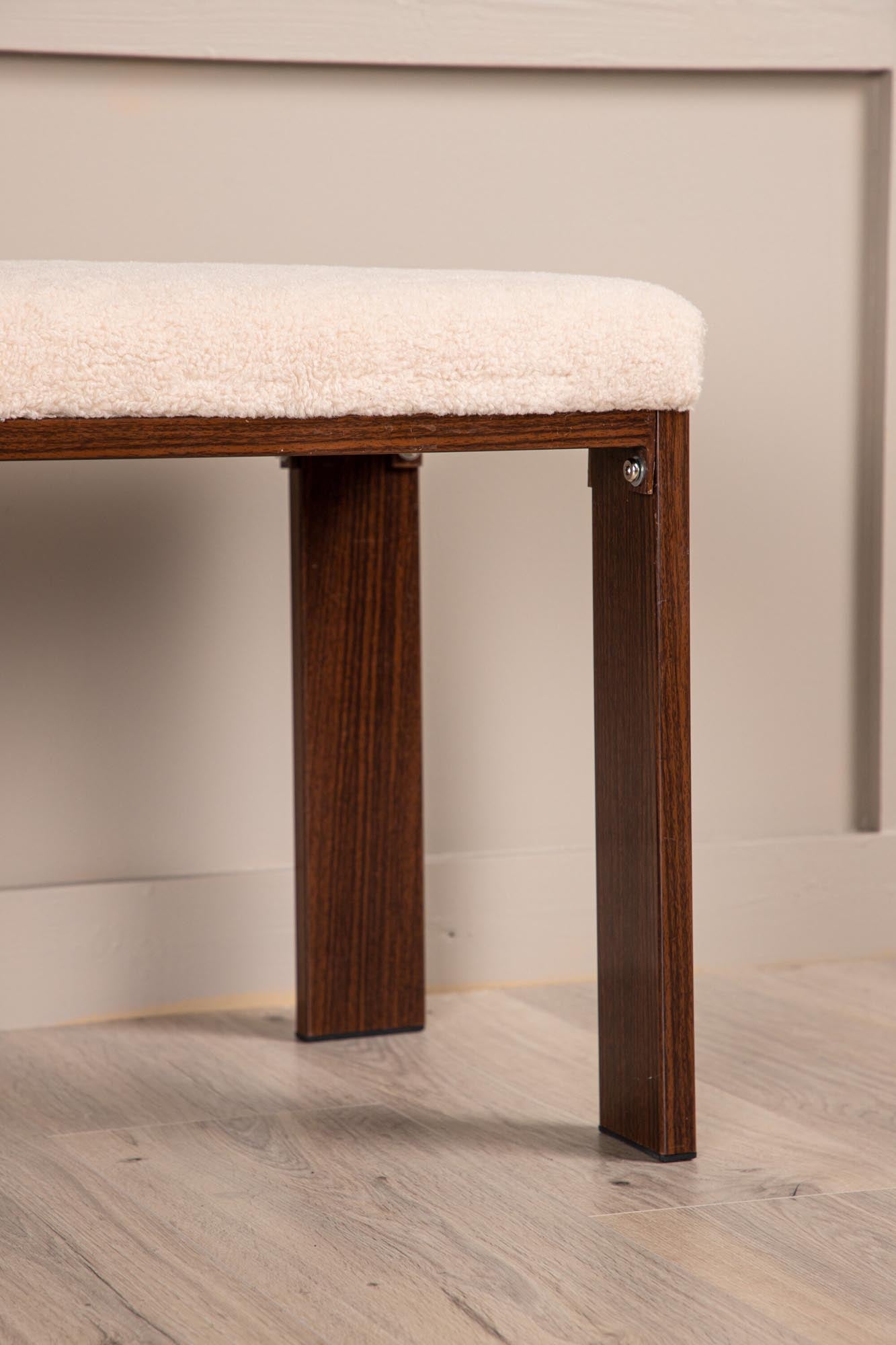 Elegante Chester Bank: Weisser Fleecestoff, Walnussholzbeine, Stahlkonstruktion. Komfort & Luxus für jeden Raum.