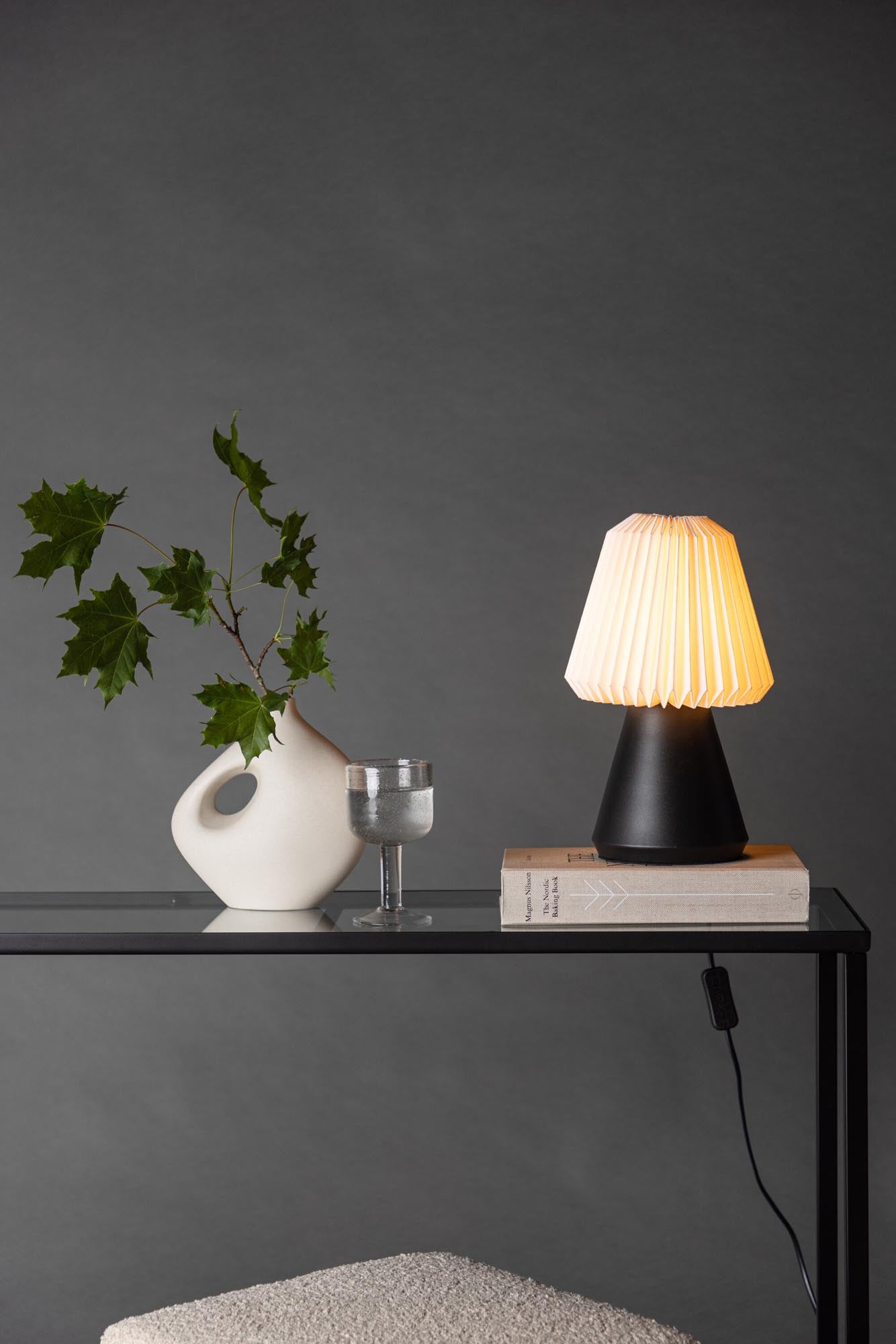 Die Fjällen Tischlampe von Venture Home: Eleganz trifft Funktionalität. Schwarzer Holzsockel, weisser Papierschirm, sanftes Licht.