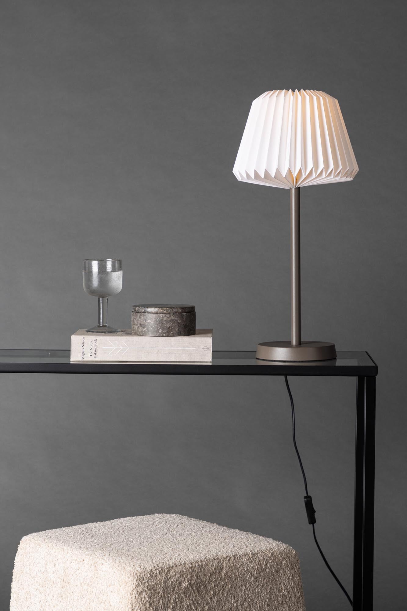 Stilvolle Tischlampe mit robustem Stahlgestell und sanftem Papierschirm, perfekt für gemütliche Abende und modernes Wohnen.