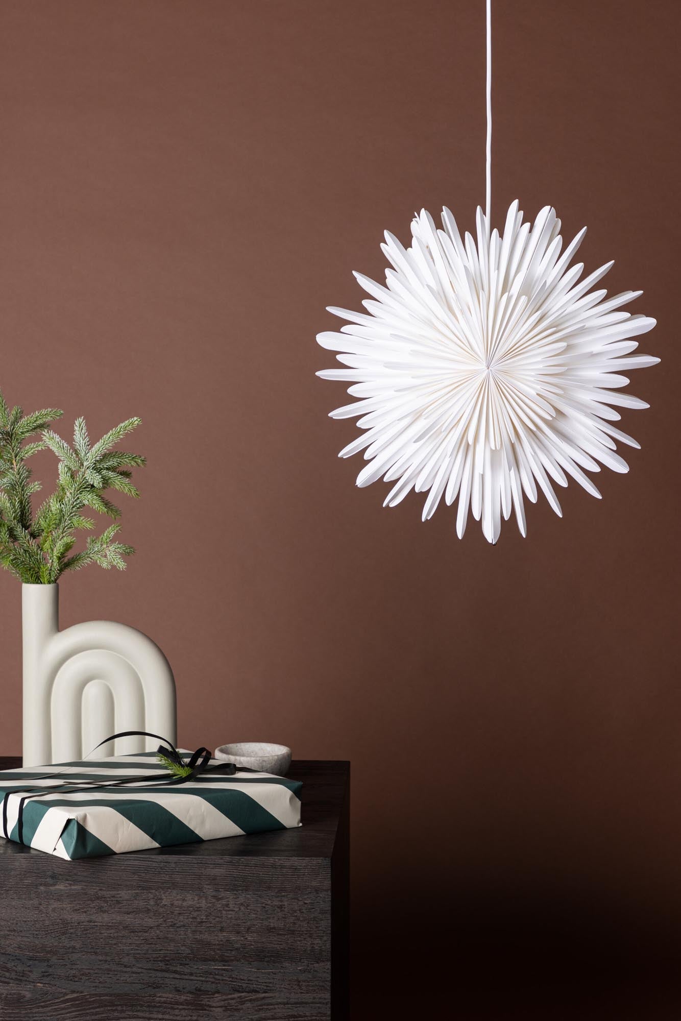 Verleihen Sie Ihrem Zuhause mit der Siegel Pendelleuchte von Venture Home einen Hauch von Eleganz. Dieser stilvolle Papierstern sorgt für eine einladende Lichtstimmung und festliche Akzente.