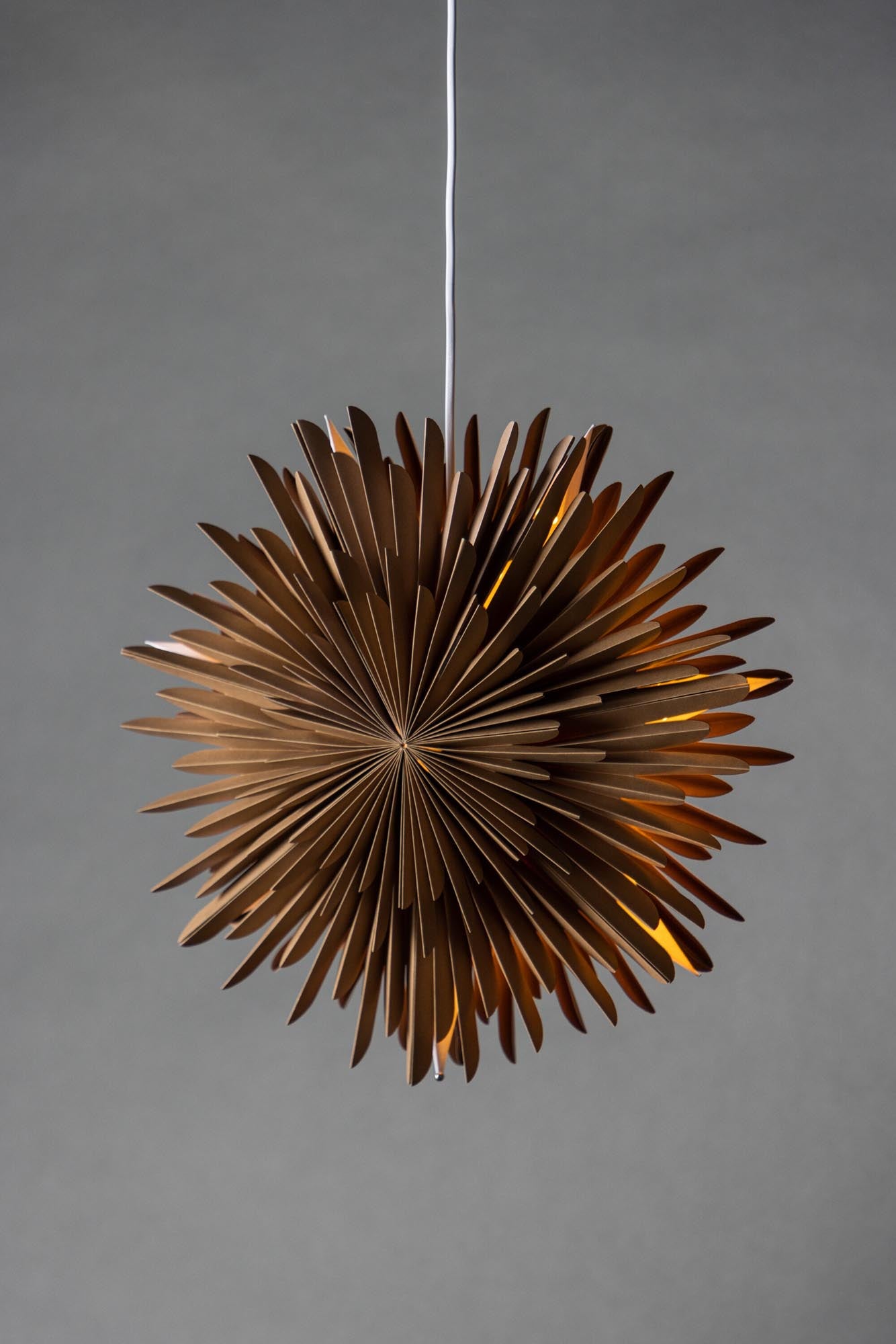 Verleihen Sie Ihrem Zuhause mit der Siegel Pendelleuchte von Venture Home einen Hauch von Eleganz. Dieser 100 cm große Papierstern sorgt für eine einladende Lichtstreuung und festliche Stimmung.