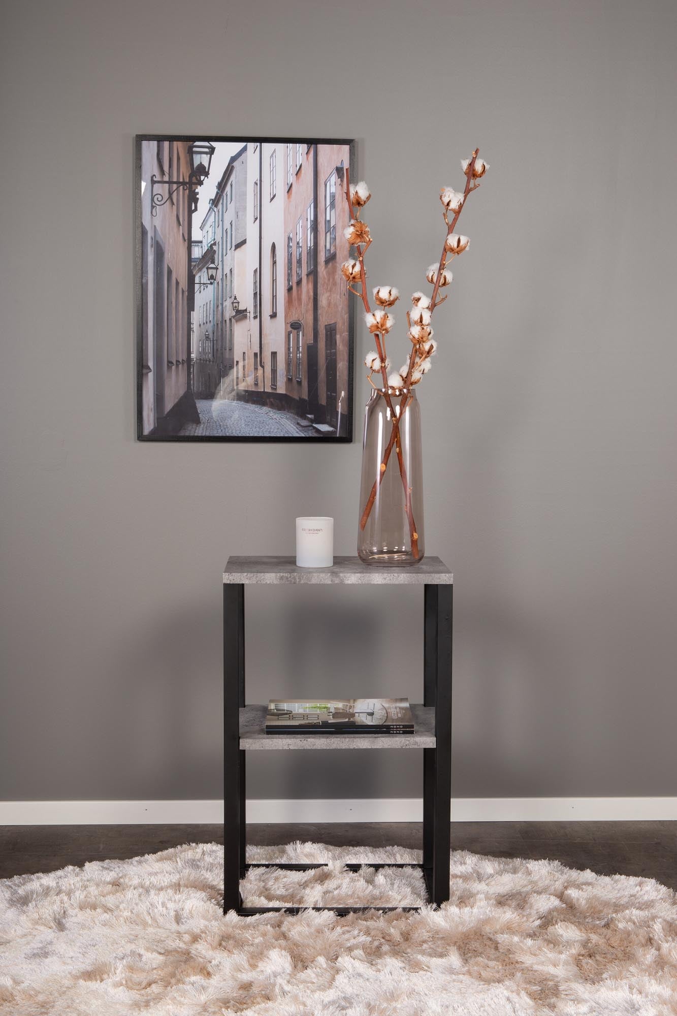 Moderner Nachttisch mit Betonoptik, MDF-Regalen und schwarzem Metallrahmen. Platzsparend, vielseitig und pflegeleicht.