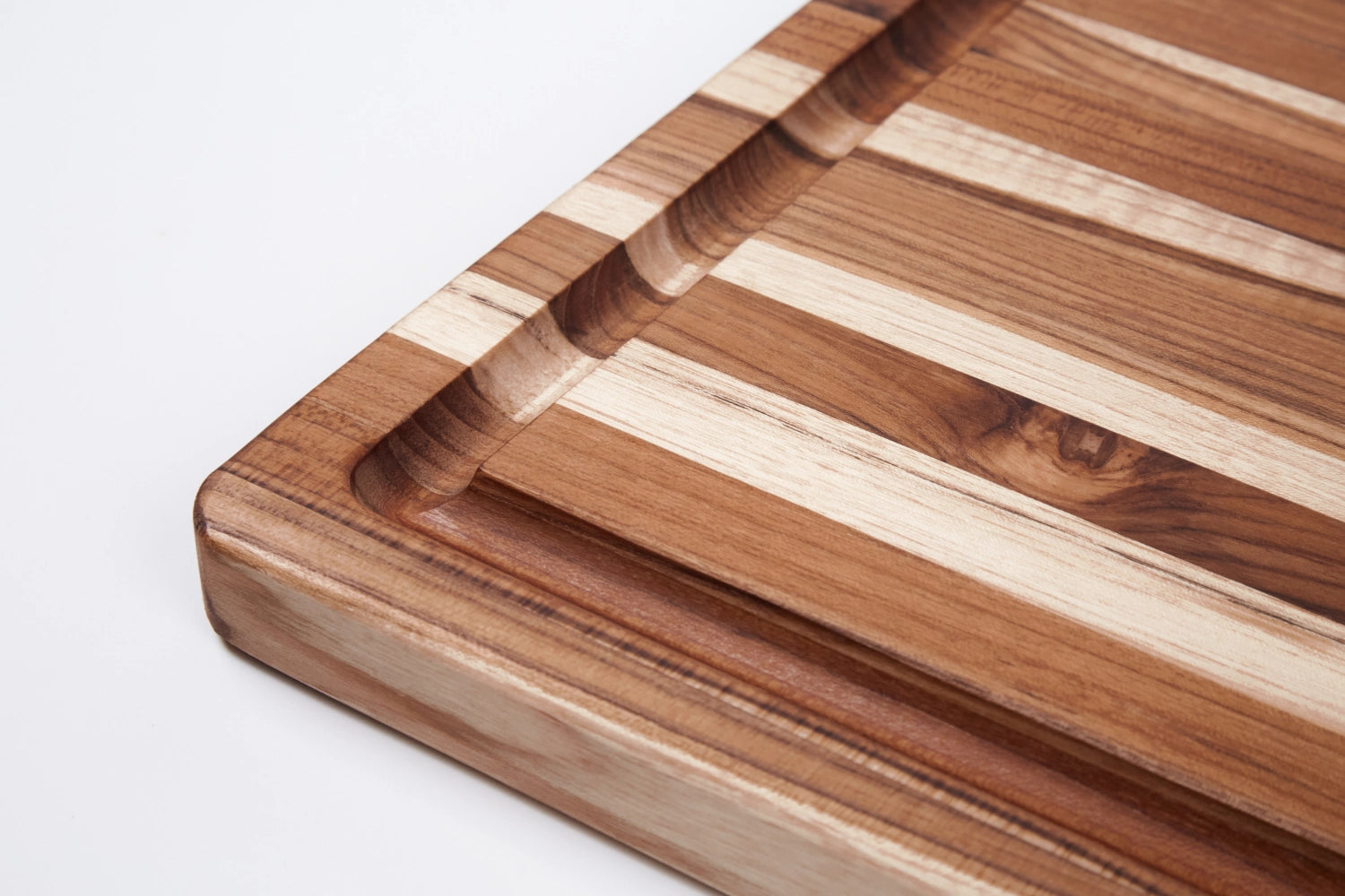 Elegantes Servierbrett aus Teakholz im skandinavischen Stil, ideal für Grillpartys. Mit praktischer Saftrille und großzügigen Maßen von 54x38x2.5cm.