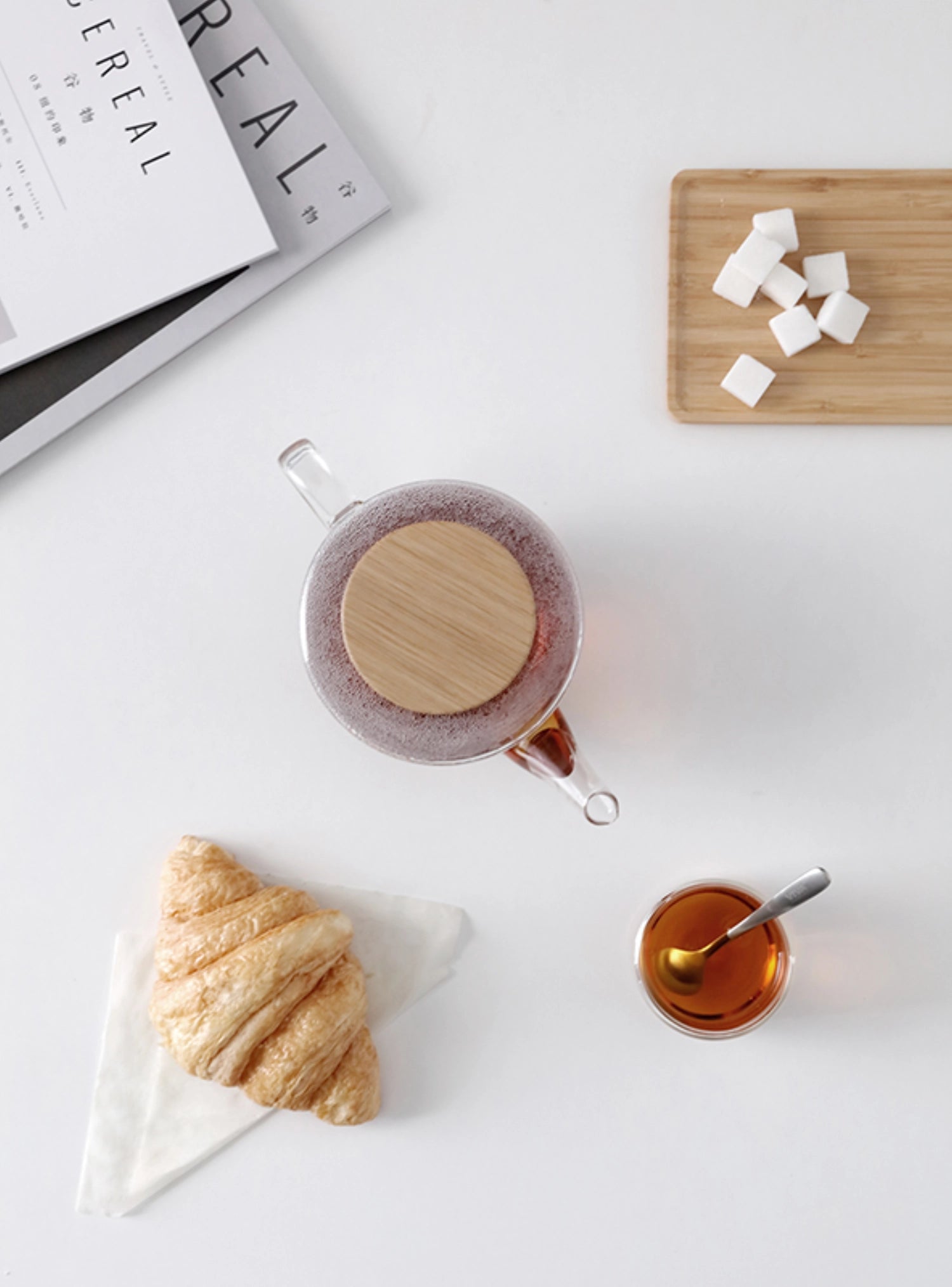 Moderner Teekrug aus hitzebeständigem Borosilikatglas, ausgestattet mit einem stilvollen Holzdeckel, perfekt für die Zubereitung von aromatischem Tee.