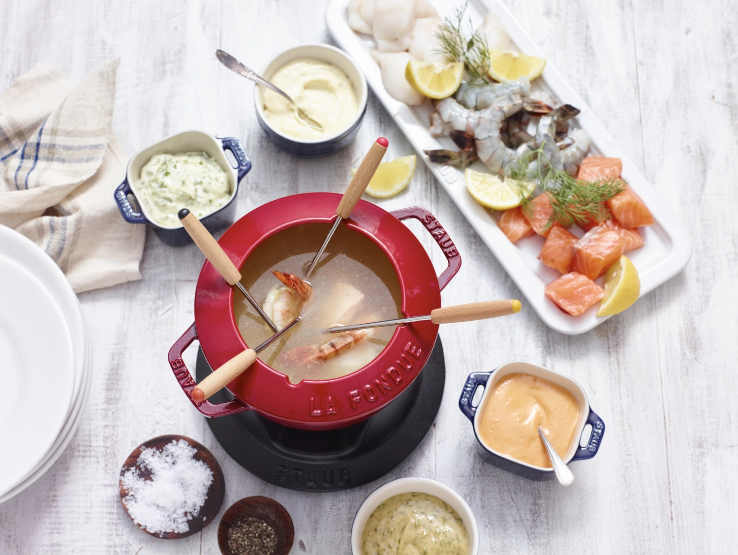 Rotes Fondue Set von Staub mit zwei Griffen, rund und 16 cm Durchmesser, ideal für gesellige Abende und köstliche Fondue-Momente.