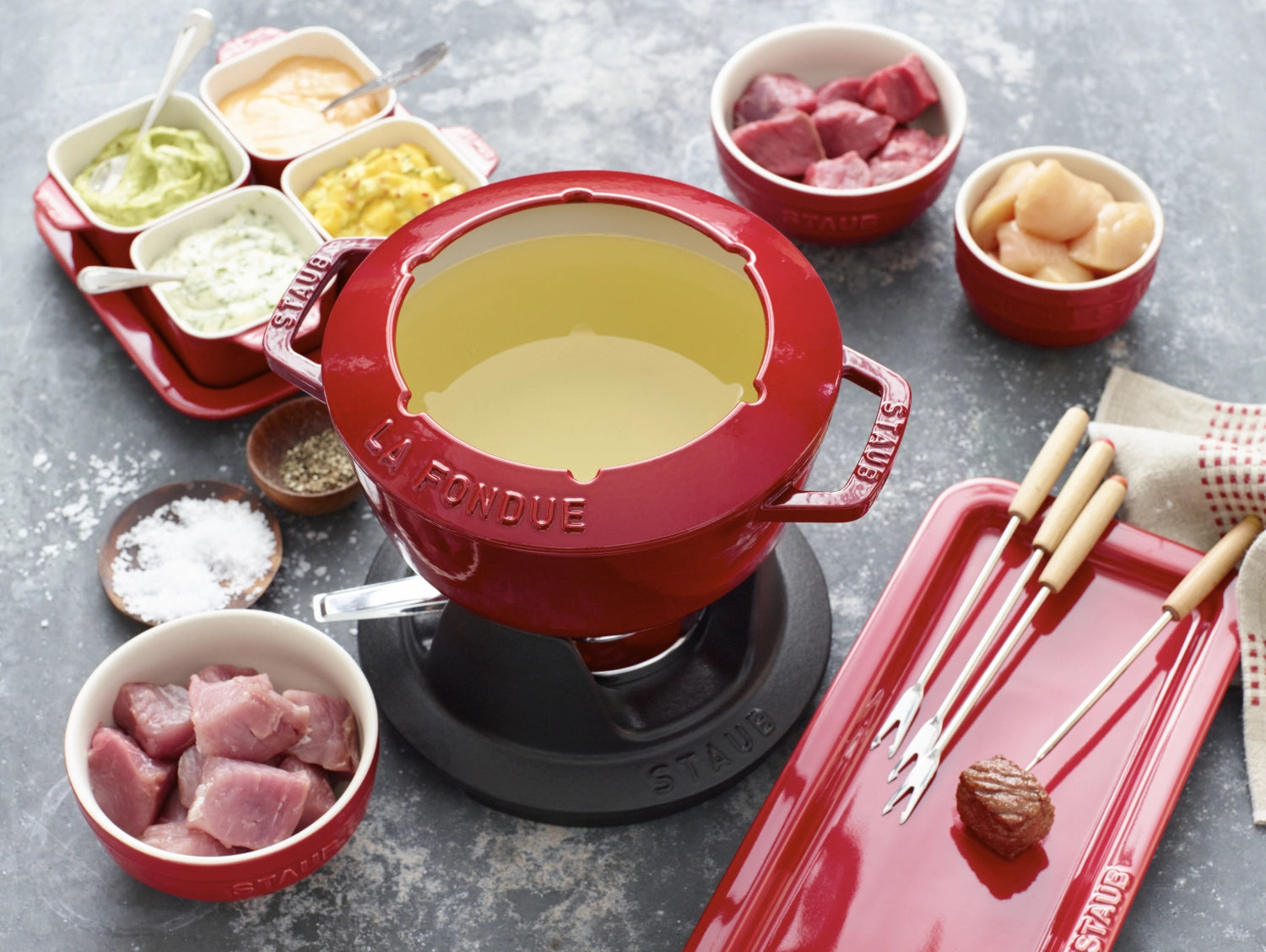 Rundes Fondue Set in leuchtendem Kirsch-Rot von Staub, 18 cm, ideal für gesellige Abende, mit praktischen Griffen für müheloses Servieren.