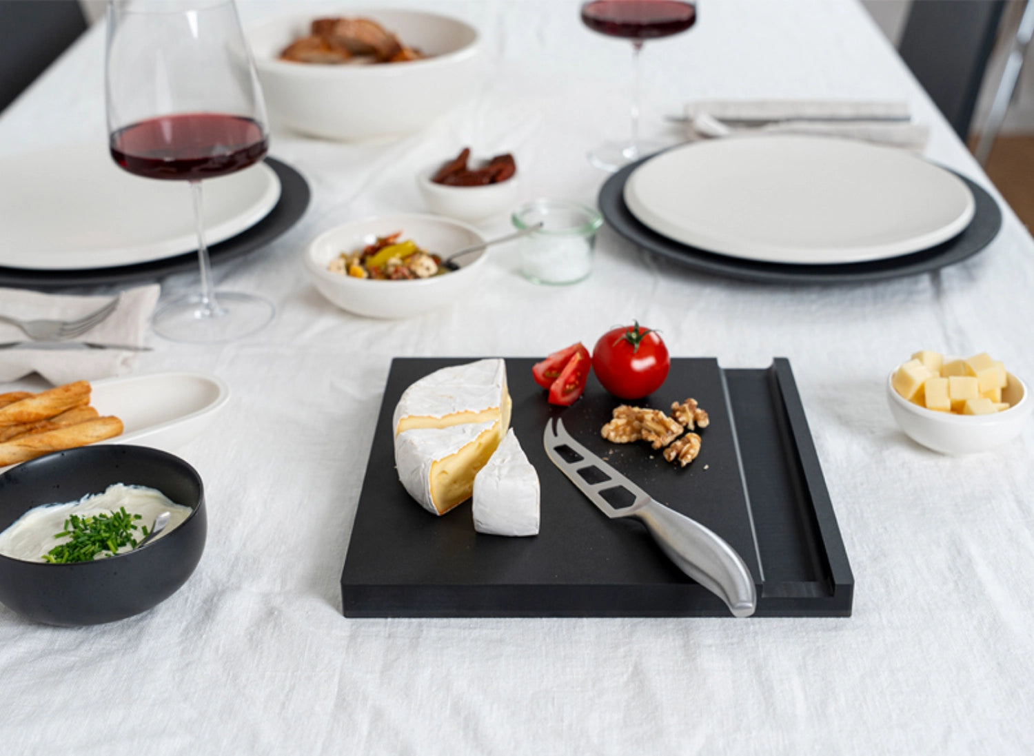 Hochwertiges Käse-Set mit schwarzem Duracore-Messer, perfekt zum Schneiden und Anrichten von Käse auf einem stilvollen Schneidbrett.
