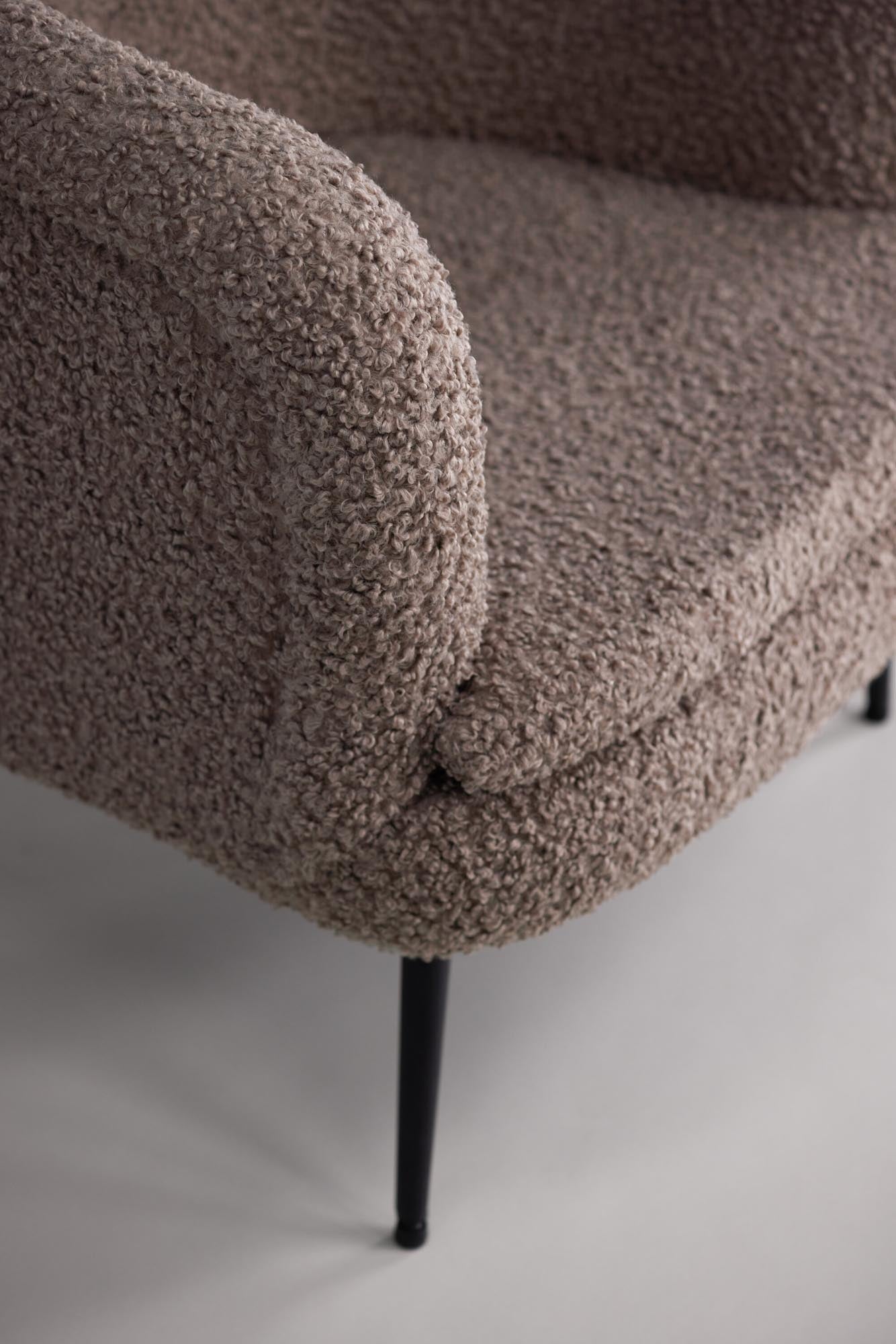 Erleben Sie den Nordkoster Sessel von Vind: Ein stilvolles Möbelstück aus kuscheligem Teddystoff und robusten Stahlbeinen, ideal für entspannte Stunden.