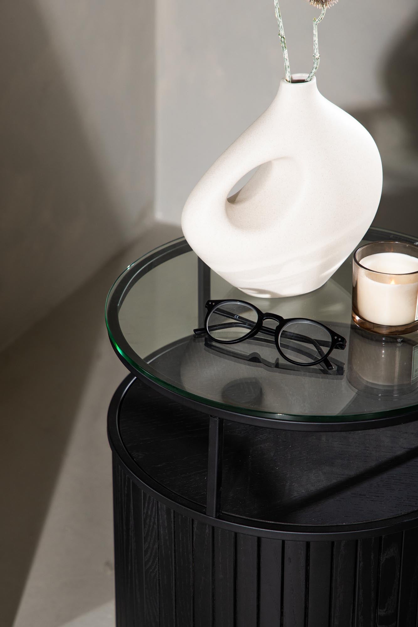 Eleganter Beistelltisch aus Metall und Glas mit Ascheholz-Details, ideal für moderne Wohnräume.