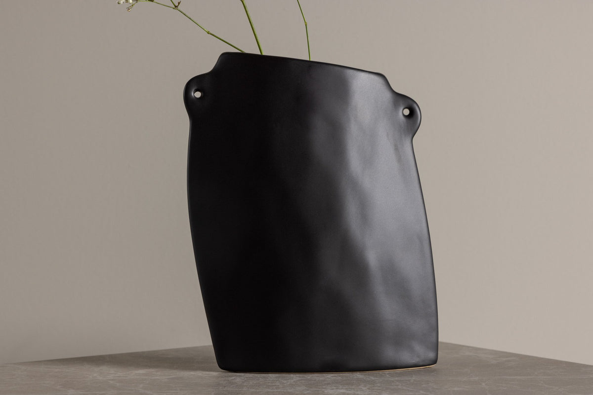 Schwarze Hie Vase von Venture Home aus Steinzeug mit schmaler Öffnung und zwei seitlichen Griffen, freigestellt fotografiert.