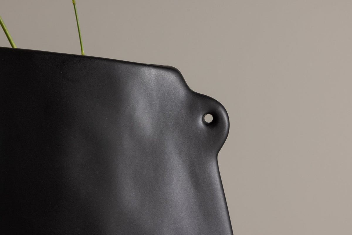 Schwarze Hie Vase von Venture Home aus Steinzeug mit schmaler Öffnung und zwei seitlichen Griffen, freigestellt fotografiert.