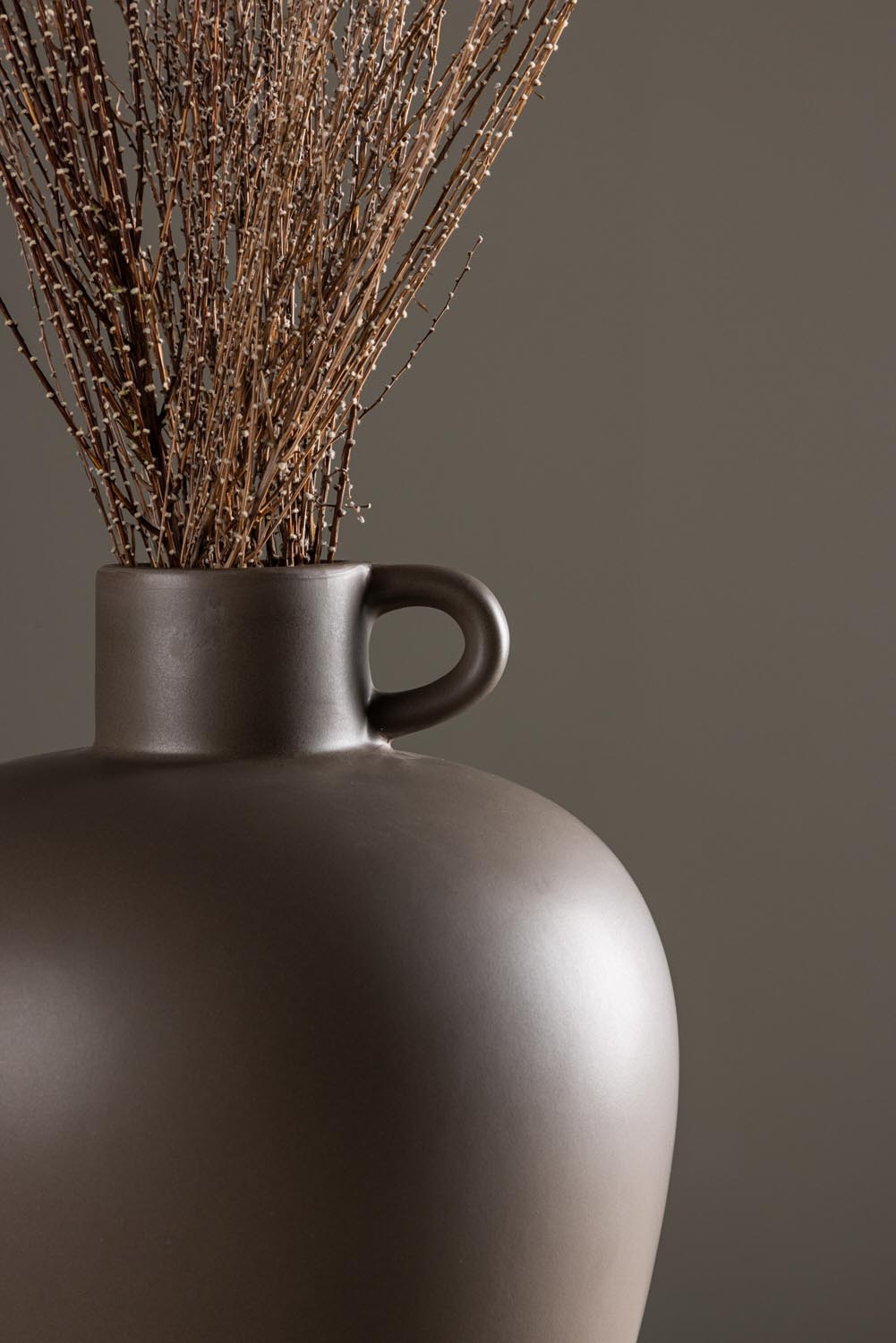 Beige Cent Vase von Venture Home aus Steinzeug mit wellenförmiger Struktur und zwei asymmetrisch angebrachten Griffen an den Seiten.